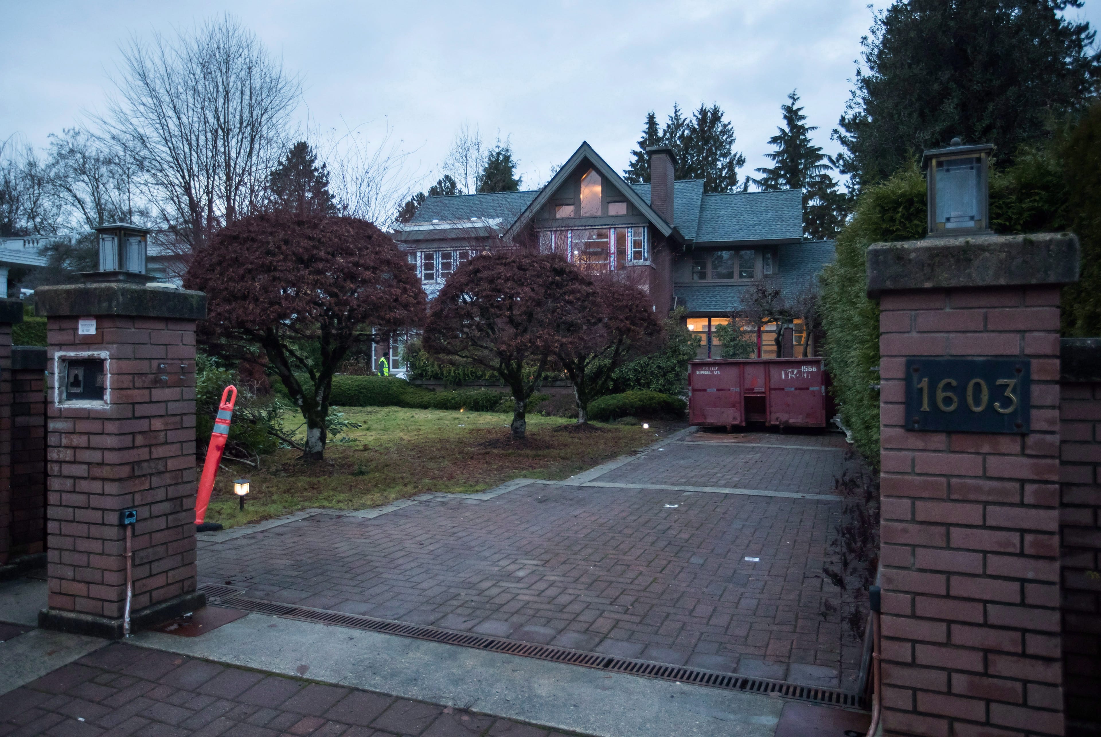 A security guard patrols outside a house owned by Huawei Technologies chief financial officer Meng Wanzhou and her husband, in Vancouver, on Monday, December 10, 2018. THE CANADIAN PRESS/Darryl Dyck