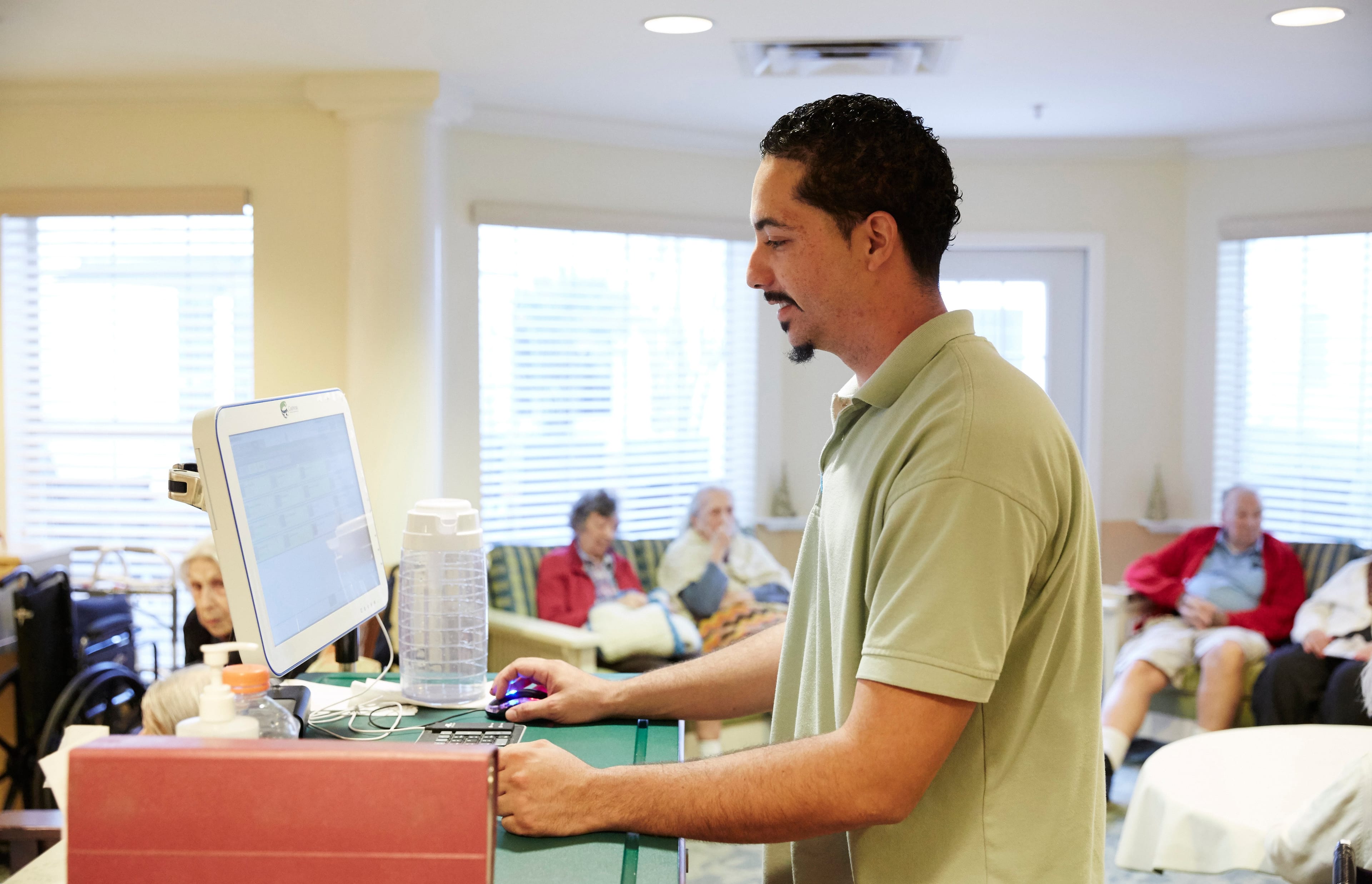 A care giver from Spring Hills Hunter's Creek, an assisted senior living facility in Orlando, using PointClickCare’s EHR platform to update residents’ care plans and track medications. (Frank Carr/PointClickCare)