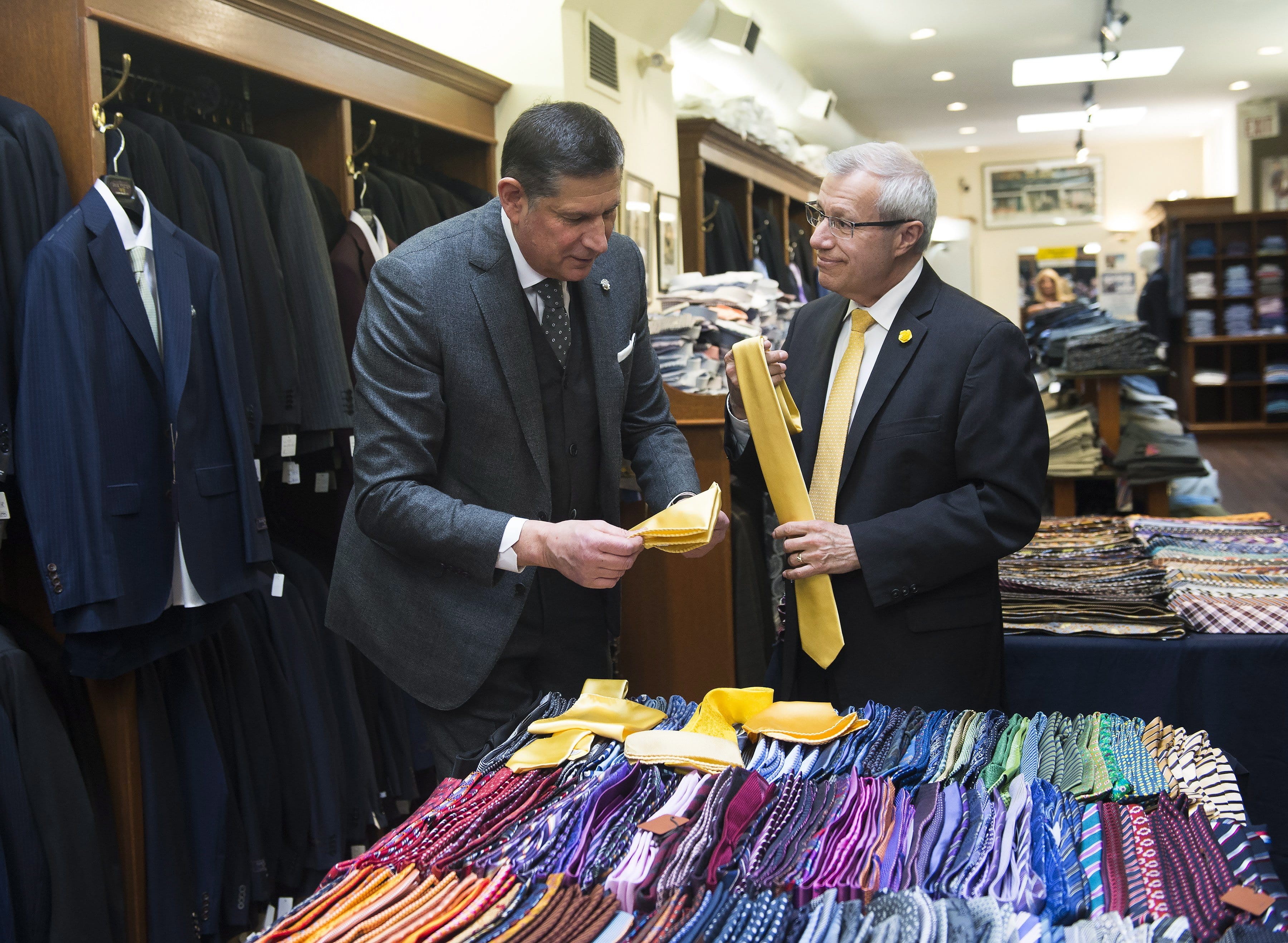 Vic Fedeli, right, Finance Minister of Ontario purchases a tie from Tomas Mihalik during a pre-budget photo opportunity in Toronto, on Tuesday, April 9, 2019. THE CANADIAN PRESS/Nathan Denette