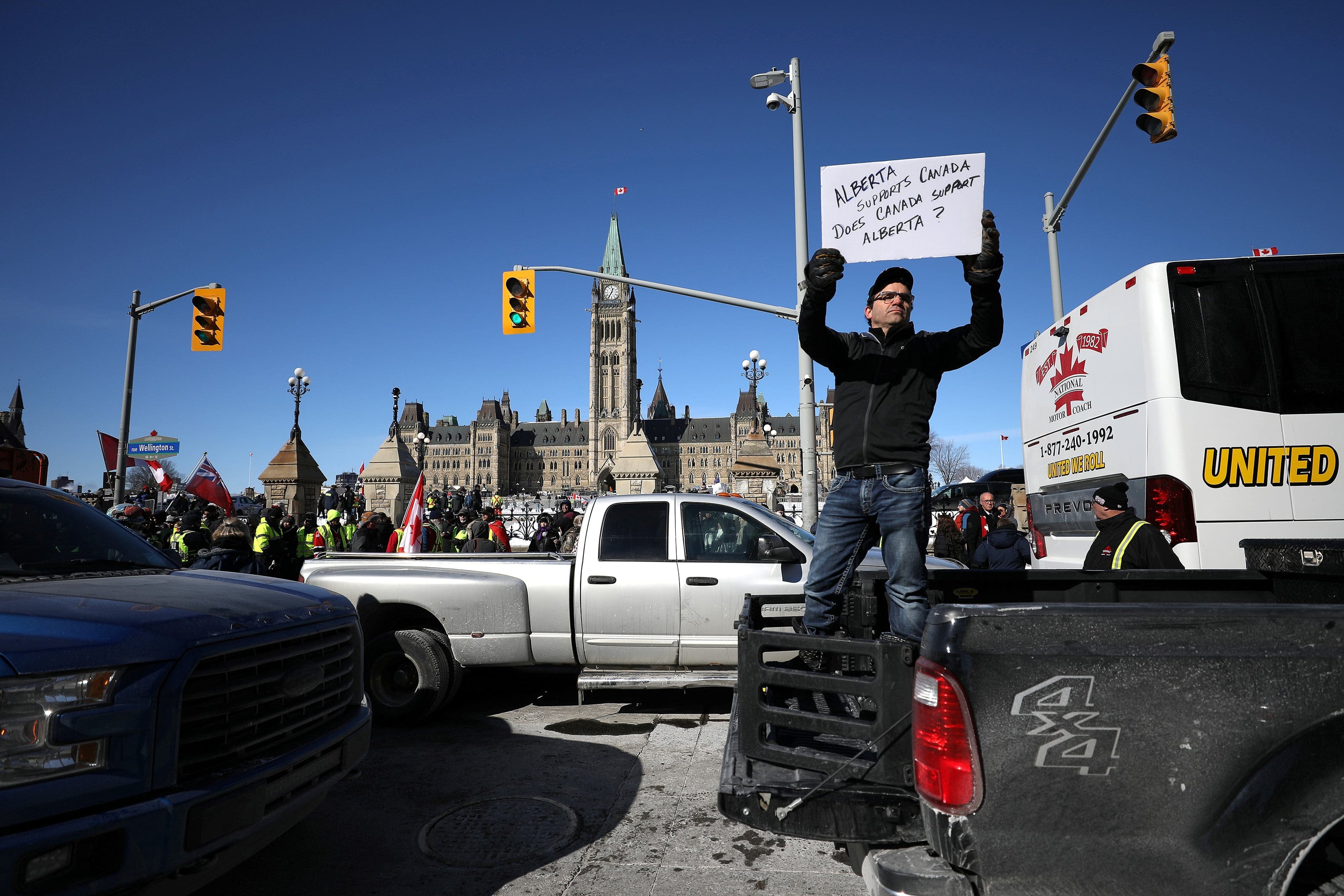 A member of the United We Roll protest convoy holds a sign during a two-day demonstration in front of Parliament Hill  (Chris Wattie/Reuters)