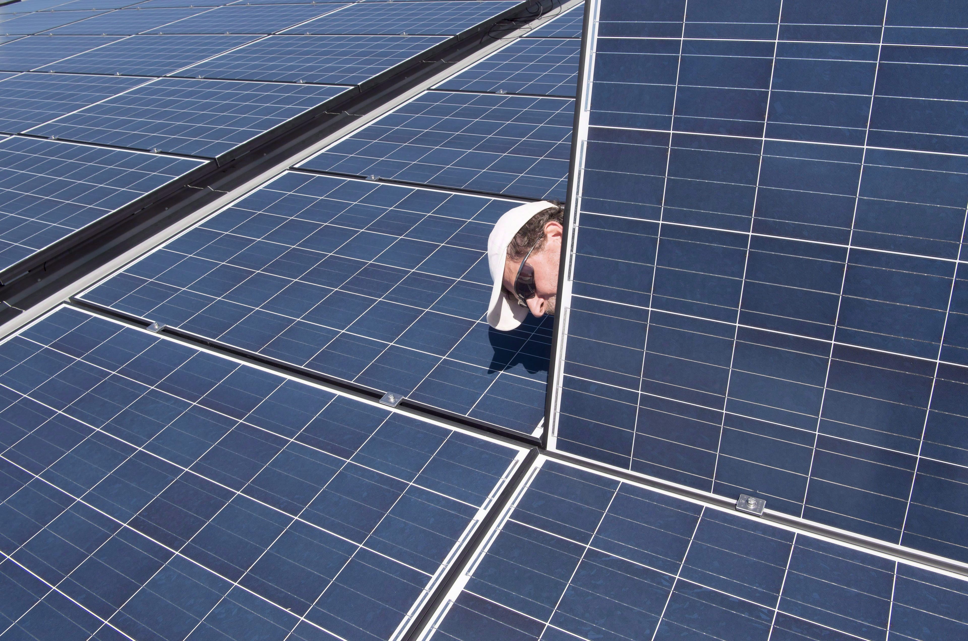 Jason Andriulaitis checks a connection under a new solar panel installation in Scugog, Ont. on Wednesday, April 27, 2016. Installing solar panels already makes sense for most homeowners in Saskatchewan and Ontario but the abundance of cheap hydroelectricity in Quebec and Manitoba means solar power may never make much economic sense in those provinces. (Frank Gunn/CP)