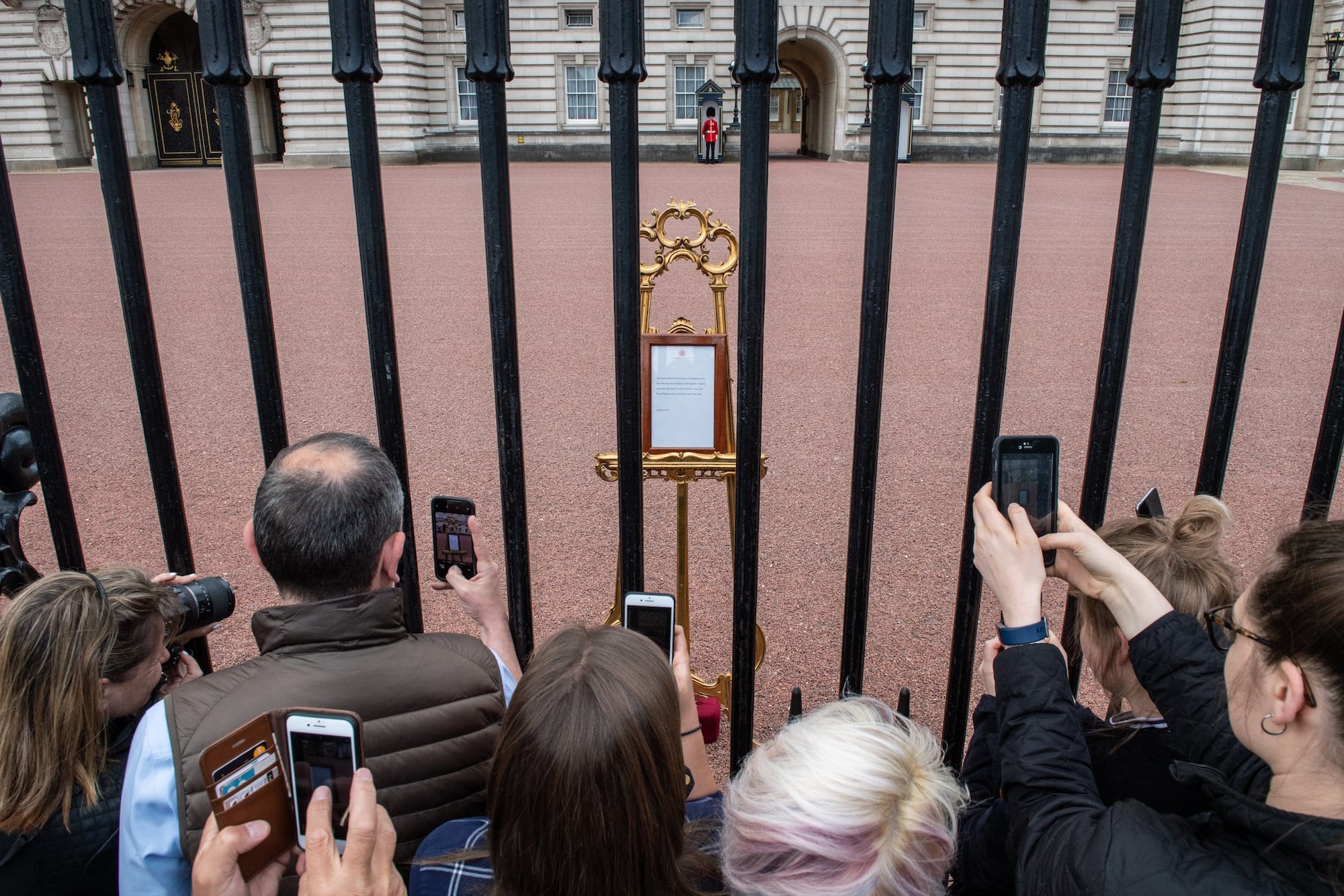 Members of the public take photographs of the official notice of the birth of a baby boy to the Duke and Duchess of Sussex outside Buckingham Palace on May 7, 2019 in London, England. (Photo by Chris J Ratcliffe/Getty Images)
