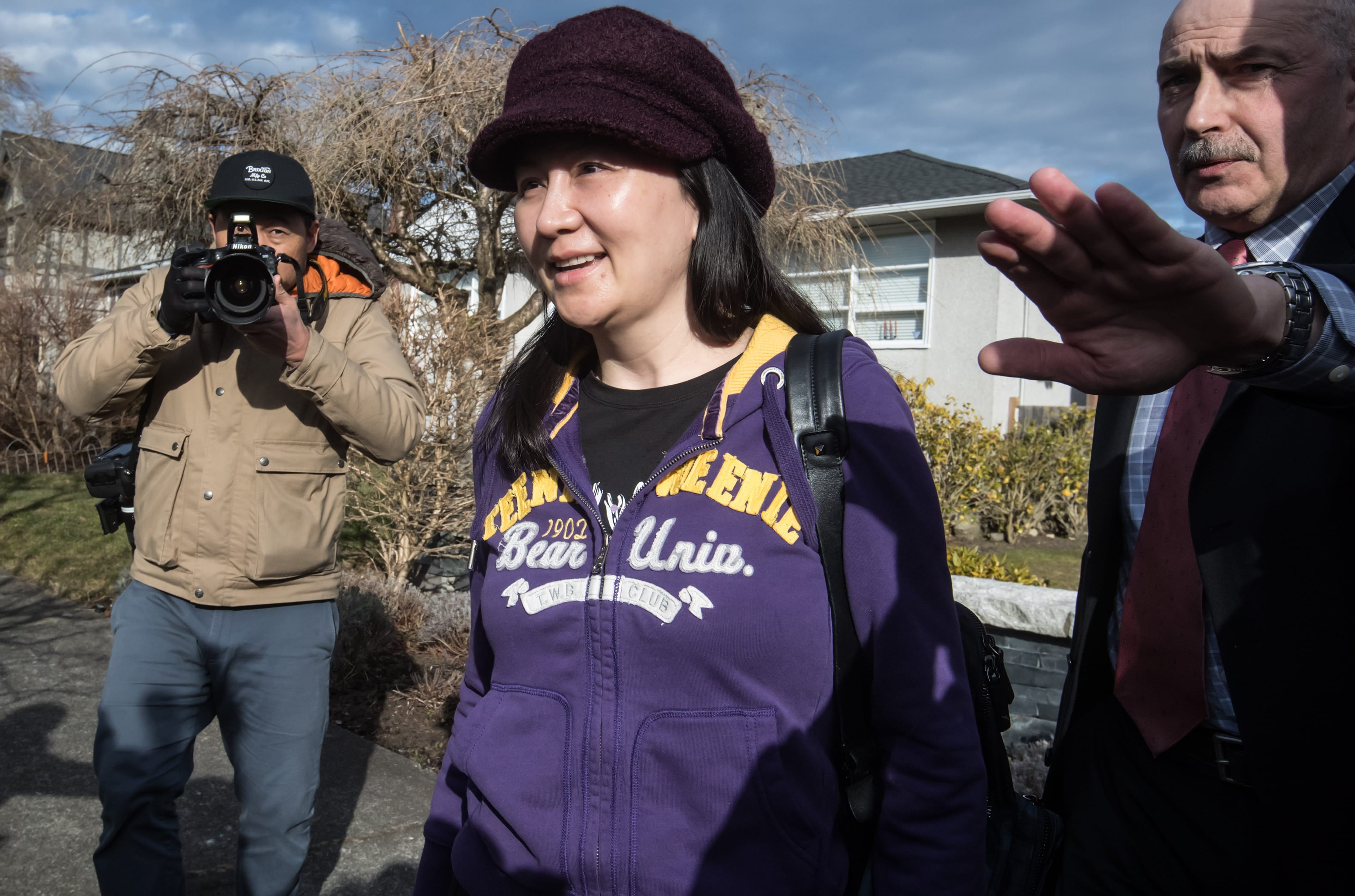 Huawei chief financial officer Meng Wanzhou, centre, who is out on bail and remains under partial house arrest after she was detained Dec. 1 at the behest of American authorities, is accompanied by a private security detail as she leaves her home to attend a court appearance in Vancouver, on Wednesday March 6, 2019. (Darryl Dyck/CP)