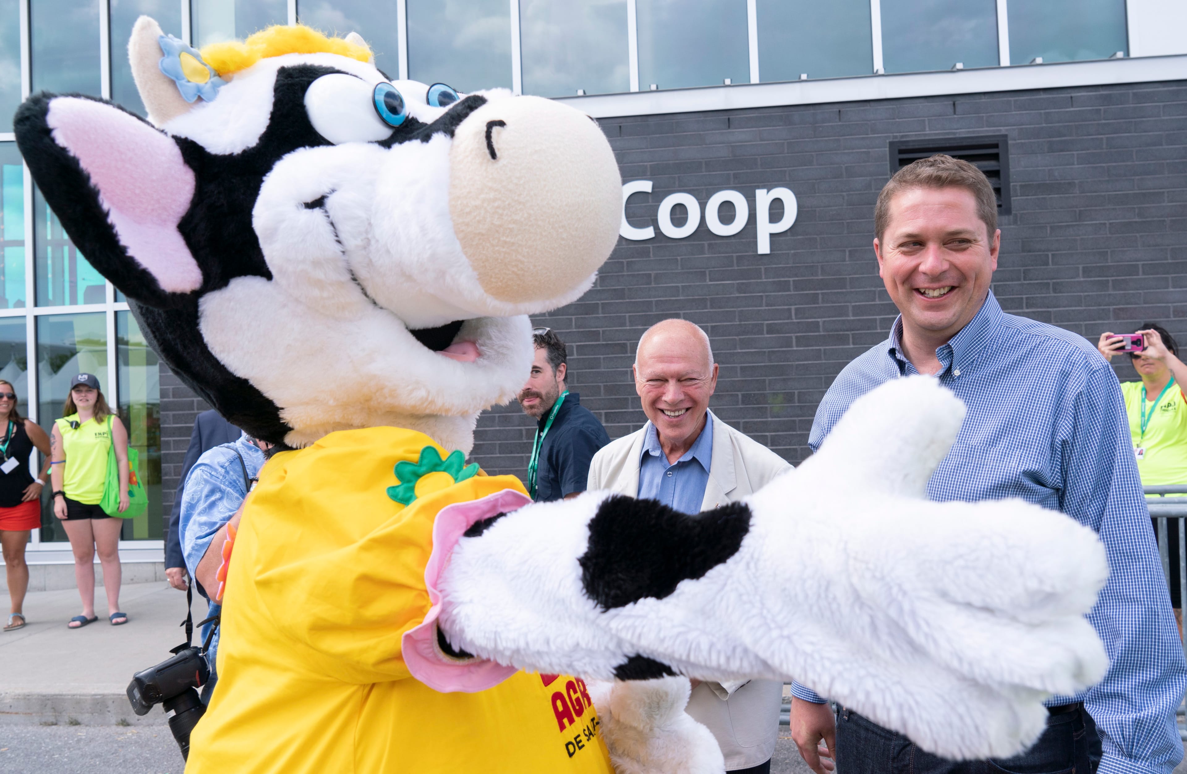 Scheer is greeted by a mascot while visiting an agricultural fair in St-Hyacinthe, Que. on July 23, 2019 (THE CANADIAN PRESS/Paul Chiasson)