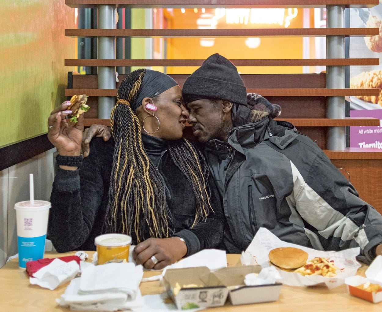 An affectionate moment over a meal in Hunts Point, N.Y. (Chris Arnade)