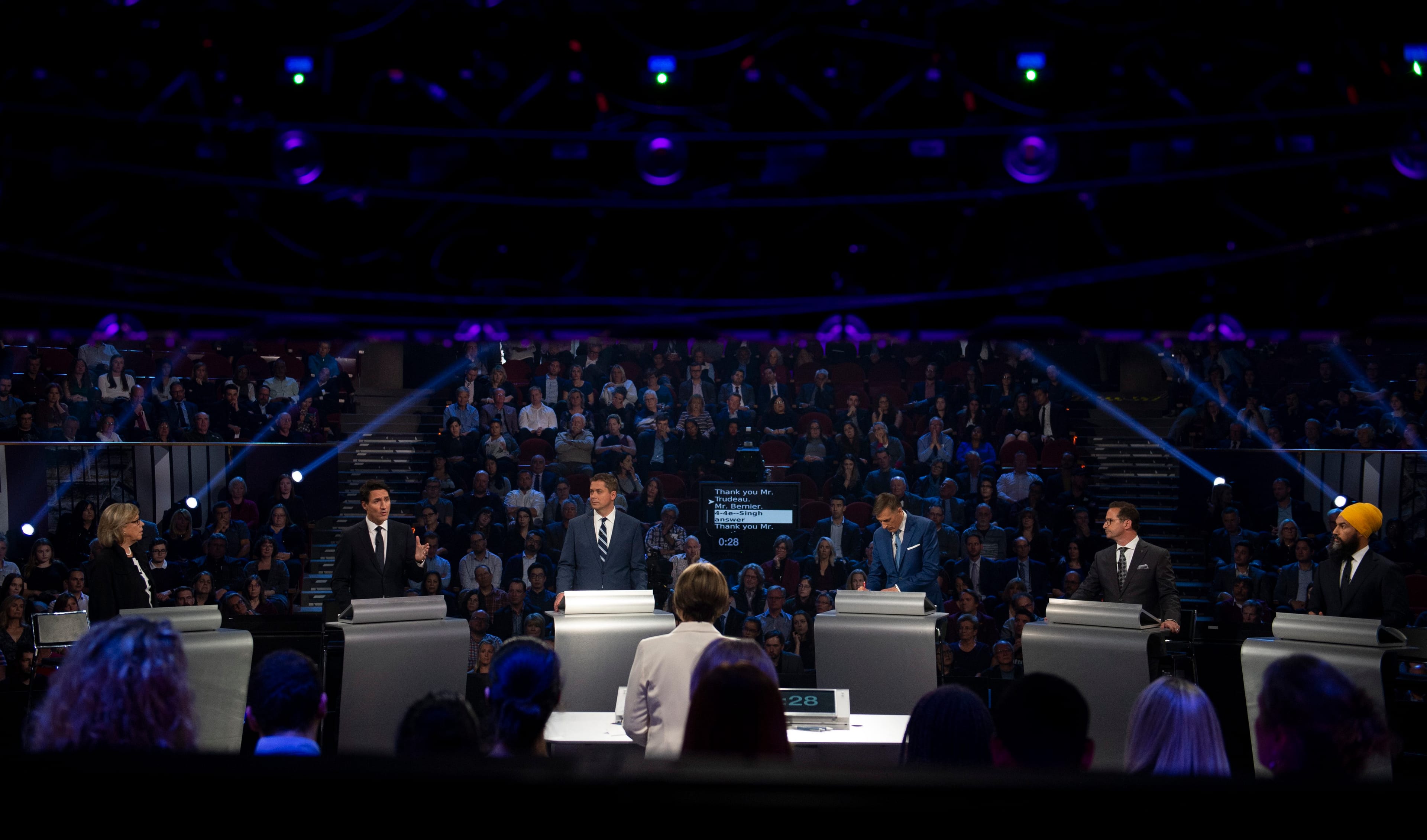 Trudeau speaks as May, Scheer, Bernier, Blanchet and Singh look on during the Federal Leaders Debate on Oct. 7, 2019 (Justin Tang/CP)