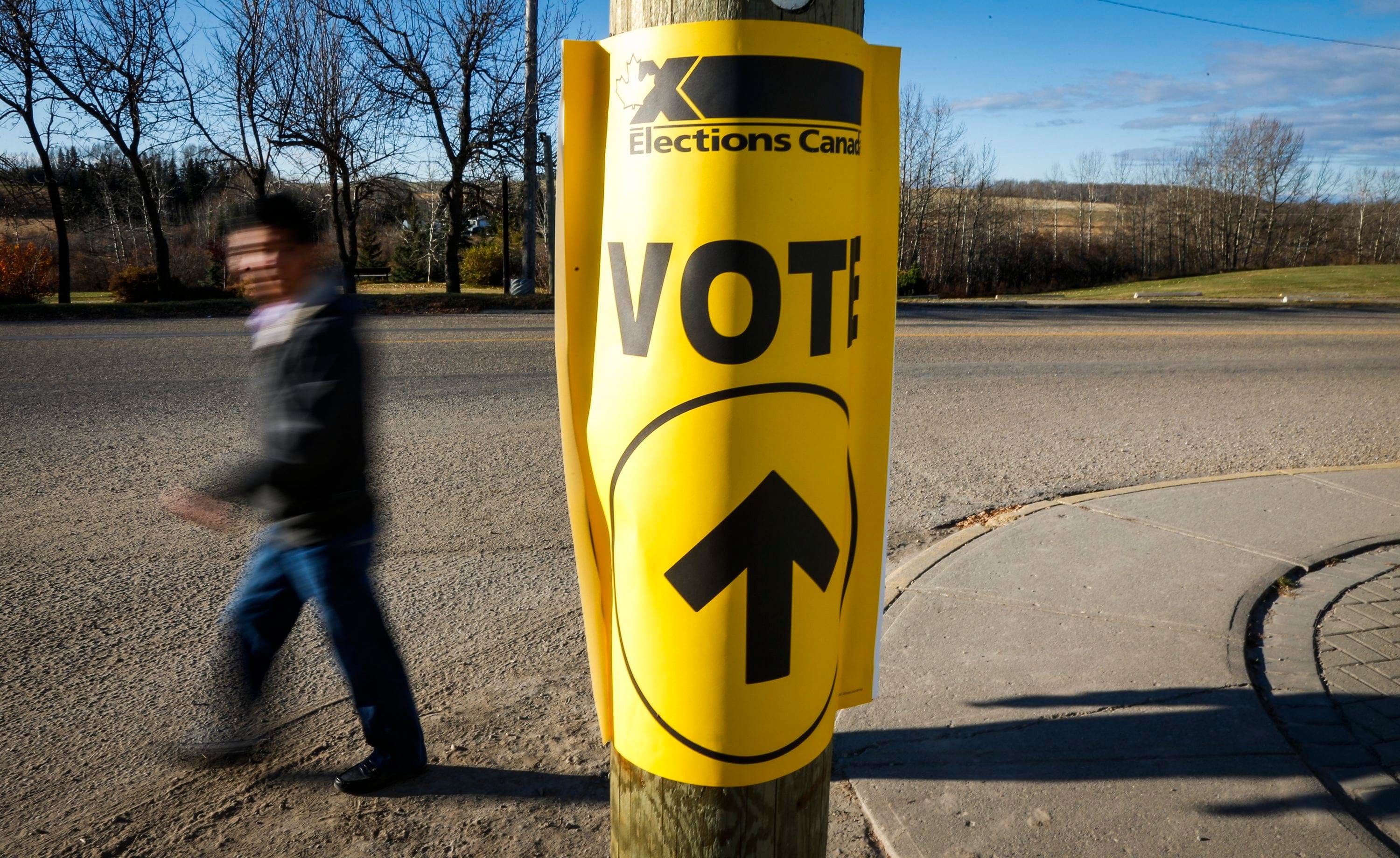 Canadians will be asked this fall to choose between moving forward with the Liberals or getting ahead with the Conservatives. A voter walks past a sign directing voters to a polling station for the Canadian federal election in Cremona, Alta., Monday, Oct. 19, 2015. (Jeff McIntosh/CP)