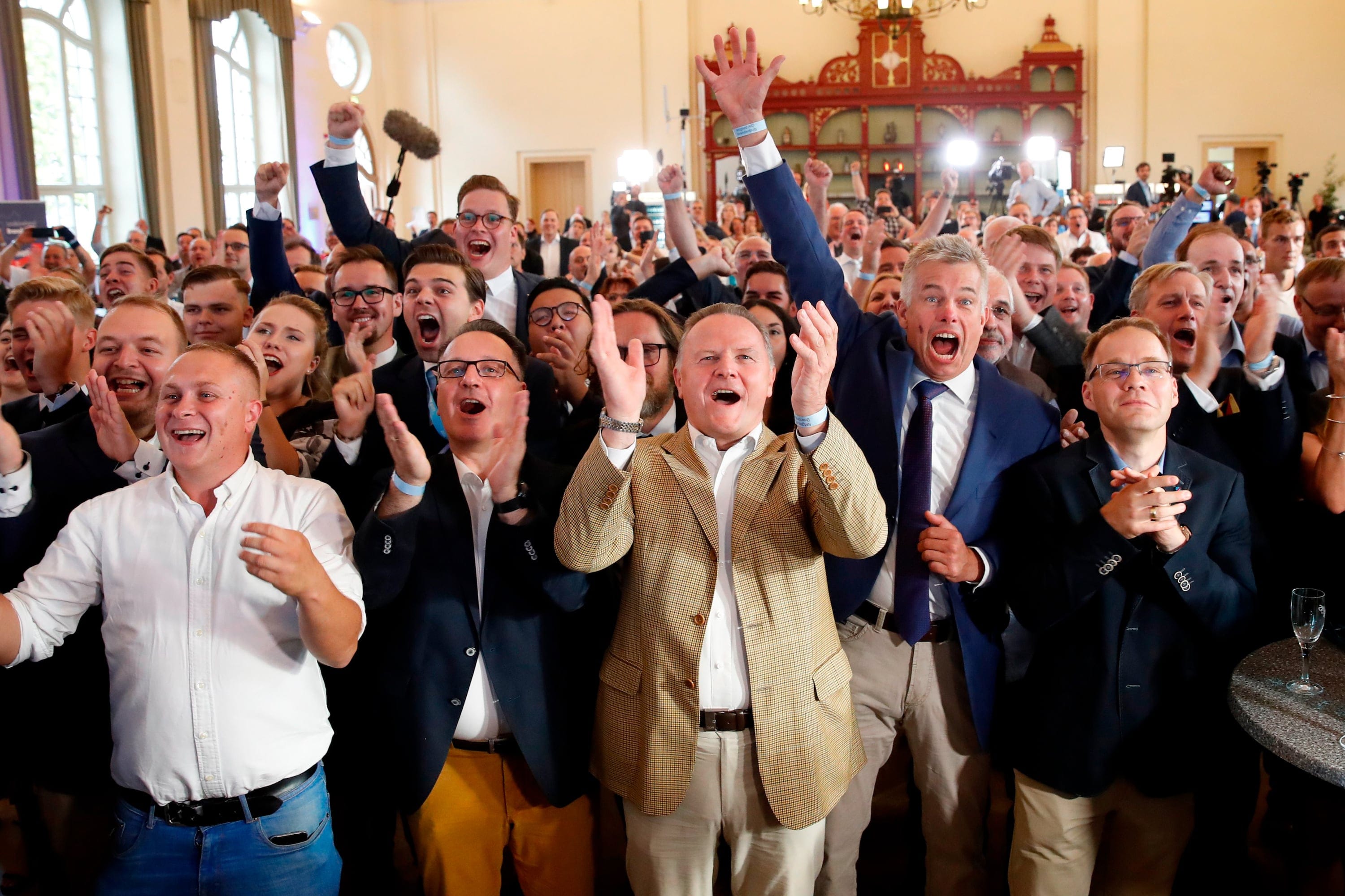 Berlin's representative of the Alternative for Germany (AfD) far-right party Georg Pazderski (C) and party supporters and members react after the first exit polls  following the state elections in Brandenburg and Saxony on September 1, 2019. (Odd Anderson/AFP/Getty Images)