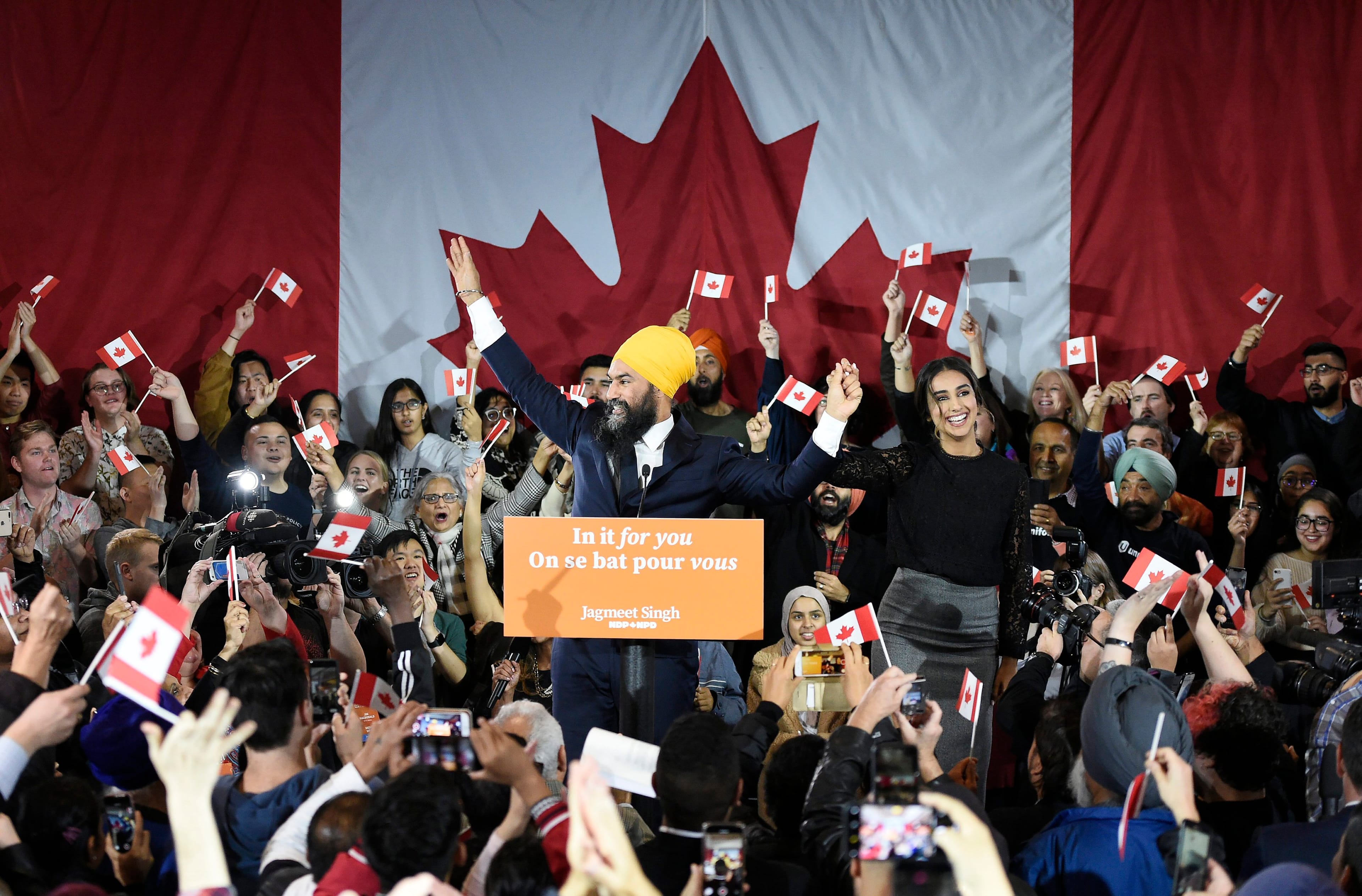 Singh and his wife Gurkiran Kaur wave to supporters on stage at NDP election headquarters in Burnaby, B.C., on Oct. 21, 2019 (Nathan Denette/CP)