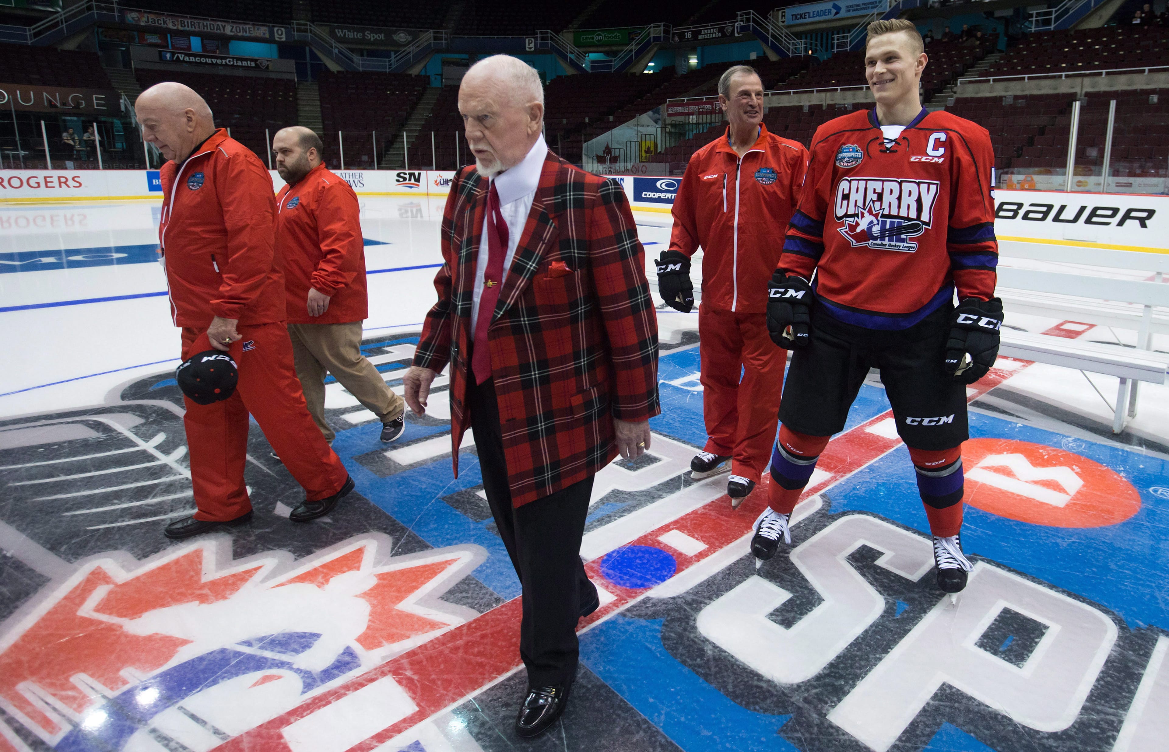 Team Cherry coach Don Cherry, centre, assistant Brian Sutter, back right, and Jakob Chychrun, right, who plays for the OHL's Sarnia Sting, leave the ice after a team photo before the CHL/NHL Top Prospects Game in Vancouver, B.C., on Jan. 28, 2016. (CP/Darryl Dyck)