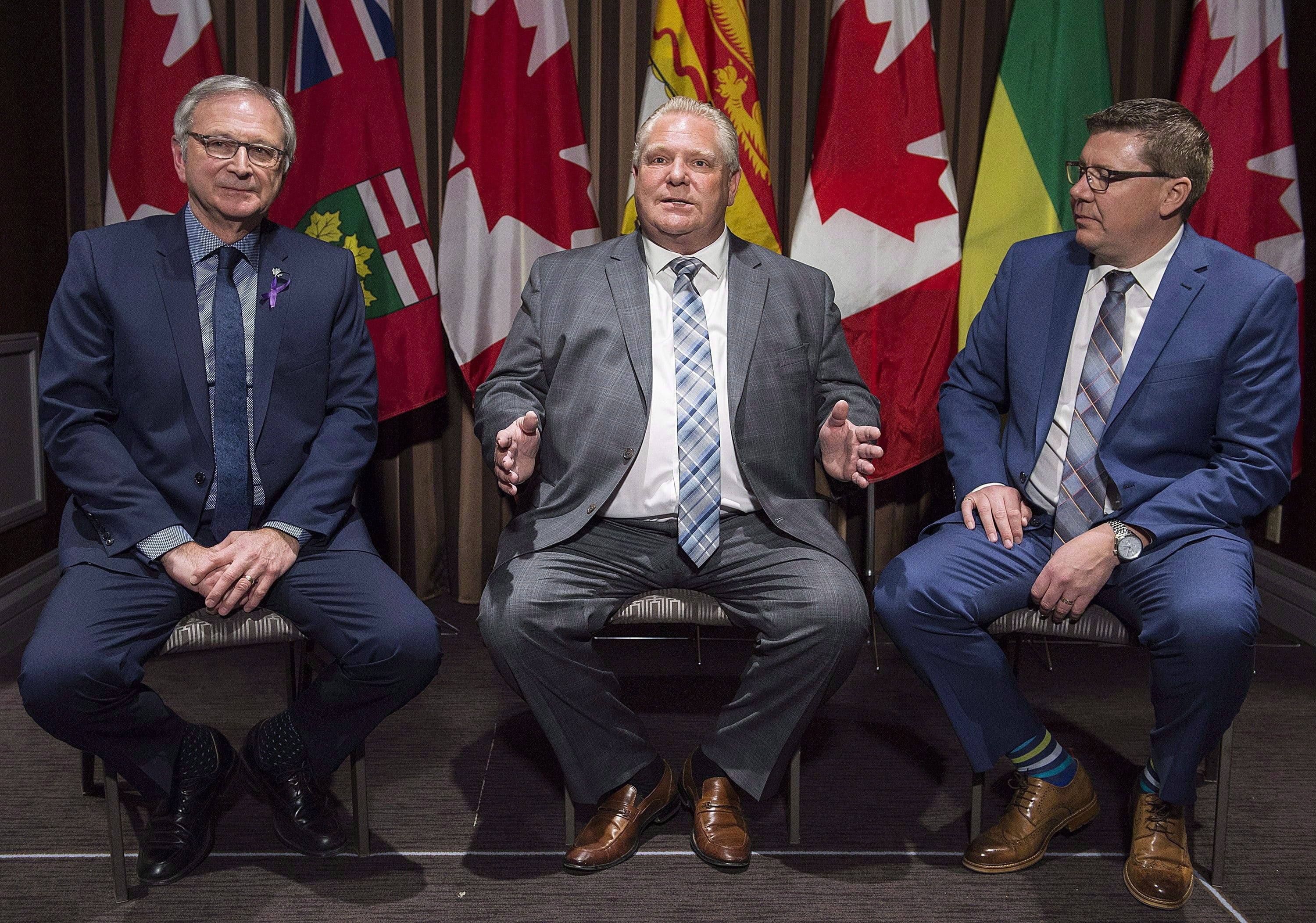 Ontario Premier Doug Ford, centre, speaks to reporters as Saskatchewan Premier Scott Moe, right, and New Brunswick Premier Blaine Higgs look on during a meeting of Canada's premiers in Montreal, Thursday, December 6, 2018. Three of Canada's premiers will announce they'll fight climate change by working together on small nuclear reactors, a company that's developing the technology says. (Graham Hughes/CP)