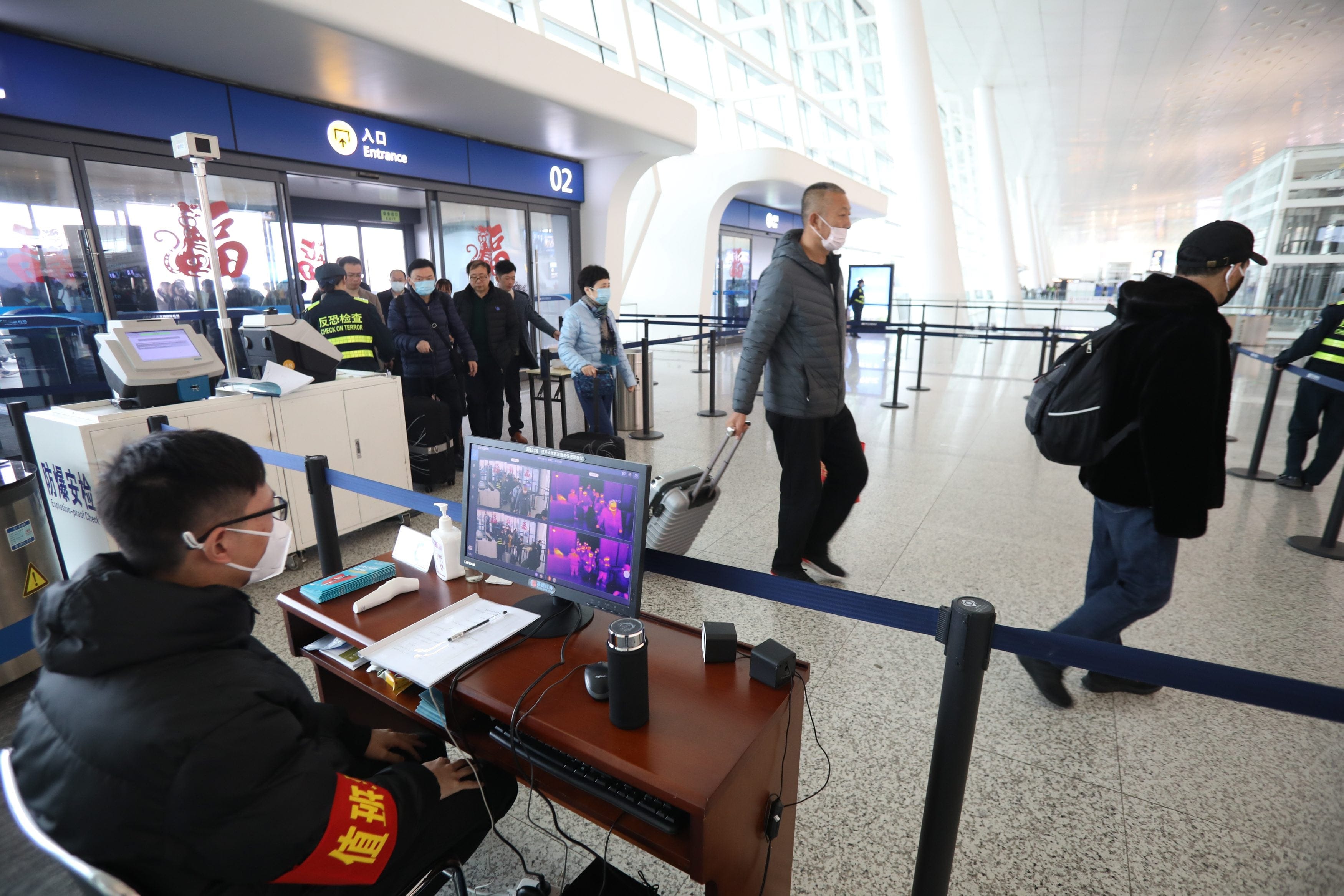 Staff take passengers' body temperature at Tianhe International Airport in Wuhan, China, the location where the coronavirus was first detected (Xiao Yijiu/Xinhua via ZUMA and CP)