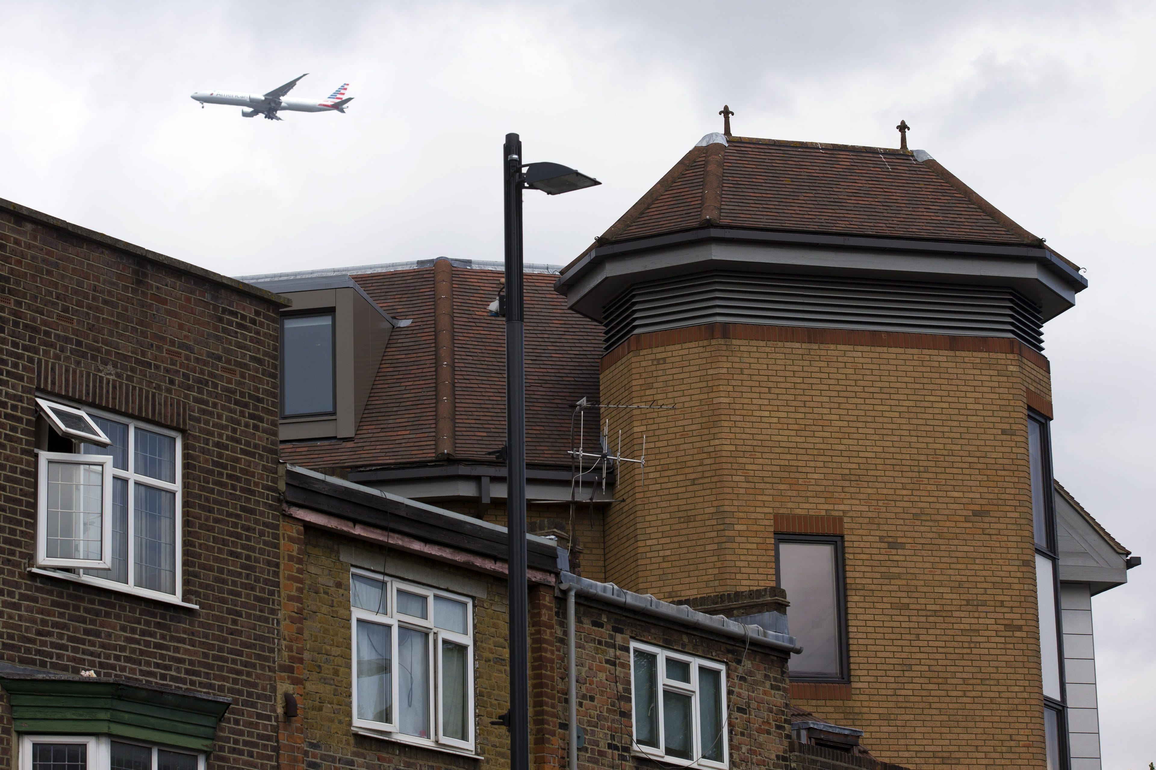A airplane flies on June 19, 2015, over a building  in Richmond where the body of a dead man was found on the roof.
(Justin Tallis/AFP/Getty Images)