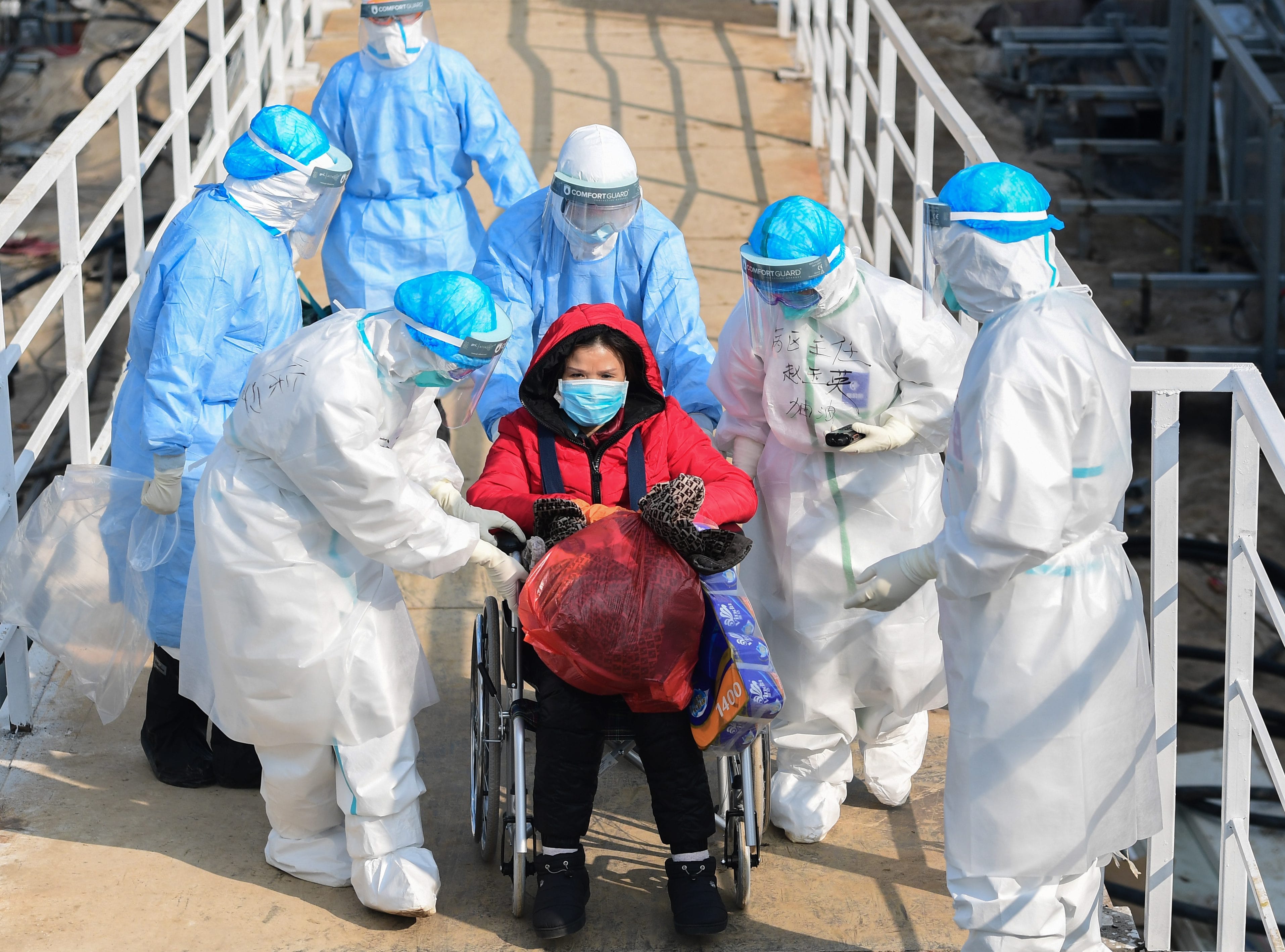 Medical staff transfer coronavirus patients to the newly completed Huoshenshan temporary field Hospital in Wuhan, China (EPA/CP)