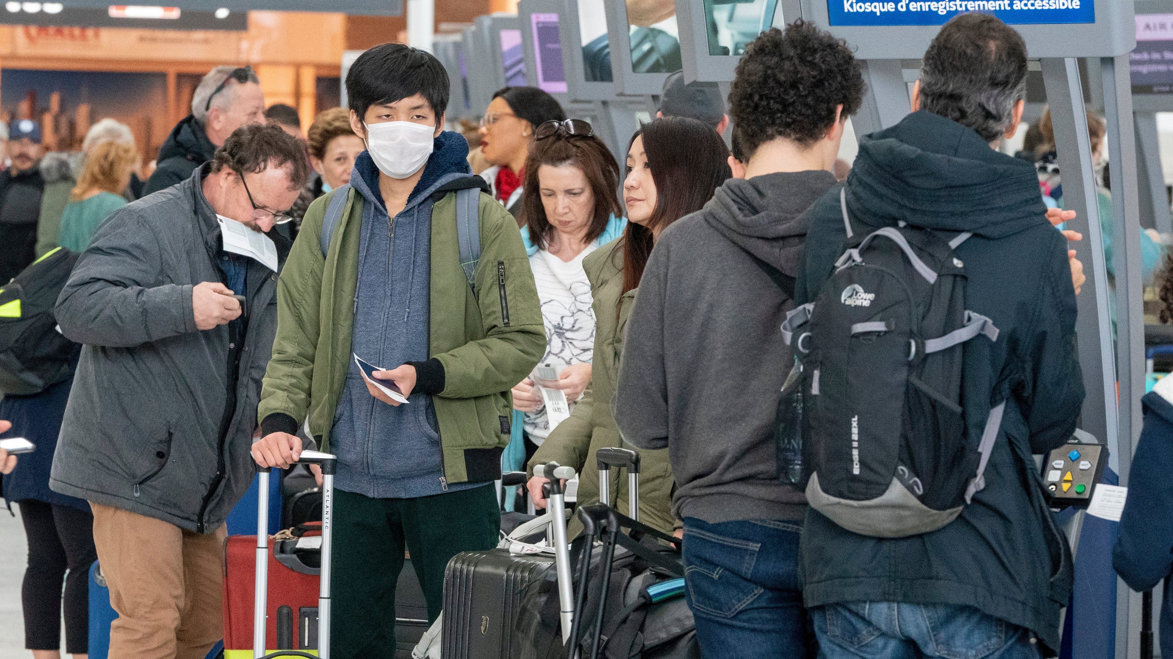 Passengers check in for their flights at Pearson Airport in Toronto on Friday, March 13, 2020. THE CANADIAN PRESS/Frank Gunn