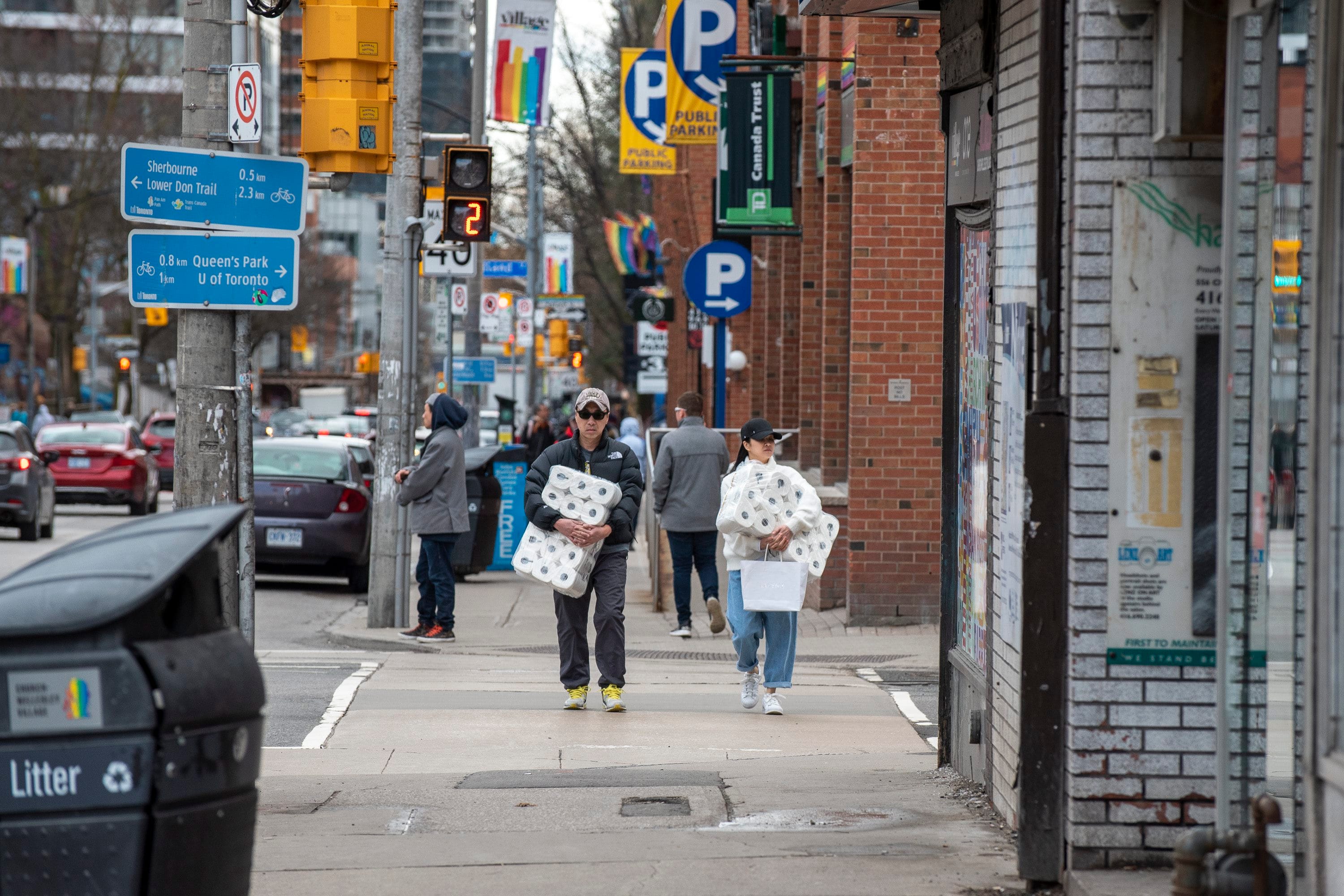 Shoppers carrying toilet paper in Toronto, on March 20, 2020 (CP/Dominic Chan)