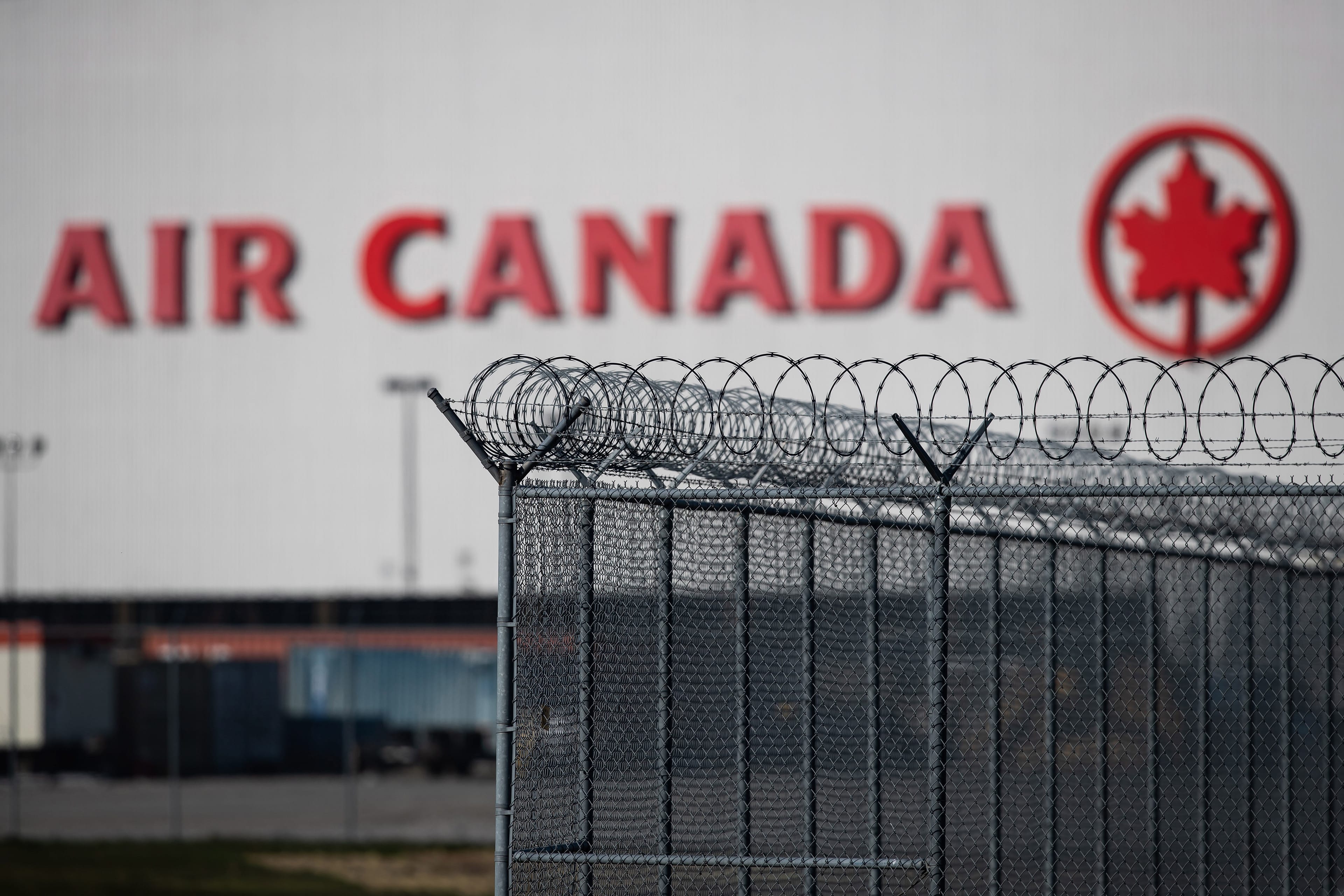 An Air Canada hangar is seen behind a security fence at Vancouver International Airport, in Richmond, B.C., on Friday, March 20, 2020. (Darryl Dyck/CP)