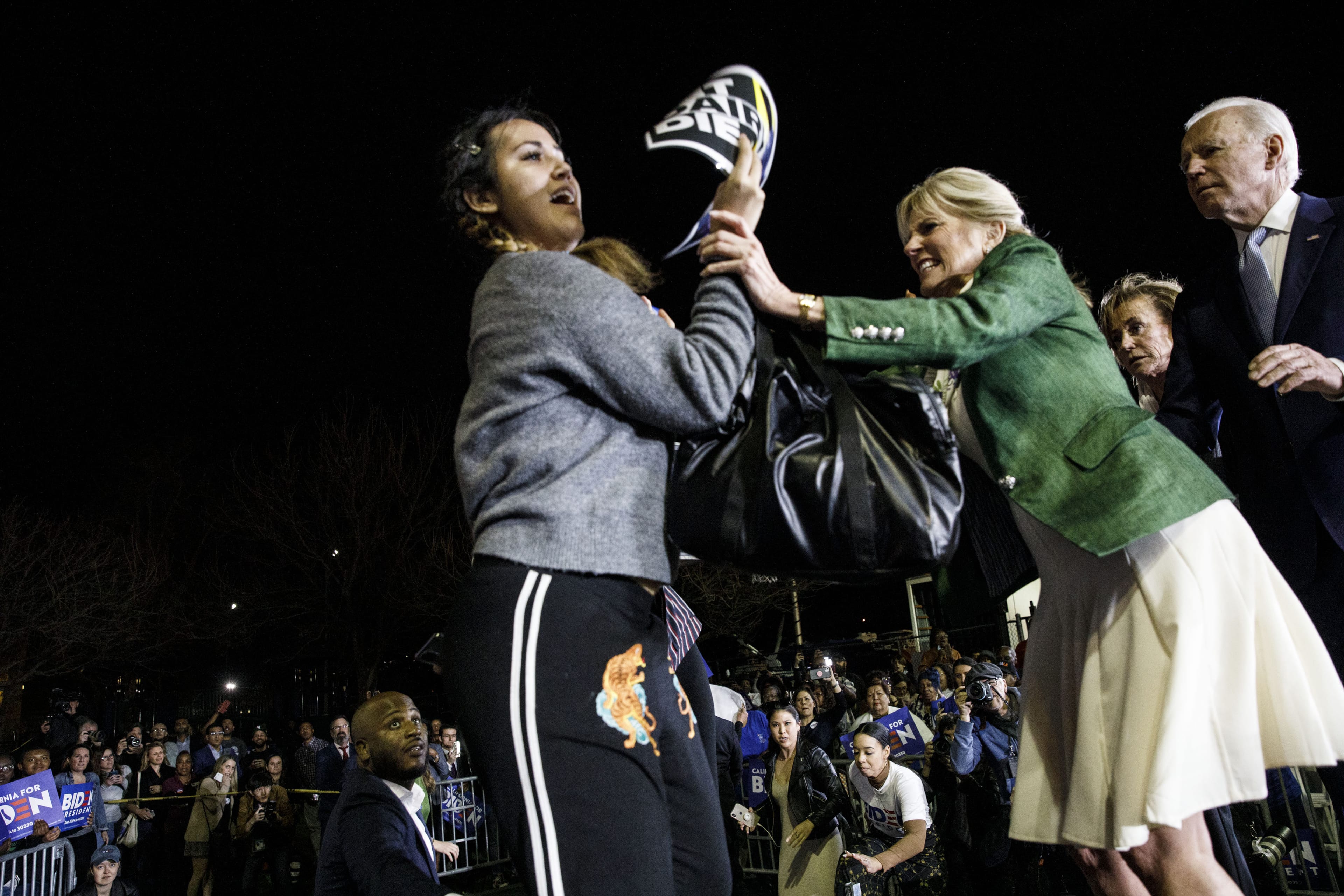 Former Vice President Joe Biden, 2020 Democratic presidential candidate, right, watches as his wife Jill Biden, center, blocks a protester from arriving on stage during an primary night rally in the Baldwin Hills neighborhood of Los Angeles, California, U.S., on Tuesday, March 3, 2020. The biggest day of the presidential primary calendar will define the nomination fight for Bernie Sanders and Biden and determine whether Michael Bloomberg and Elizabeth Warren have a rationale for carrying on their campaigns. (Patrick T. Fallon/Bloomberg/Getty Images)