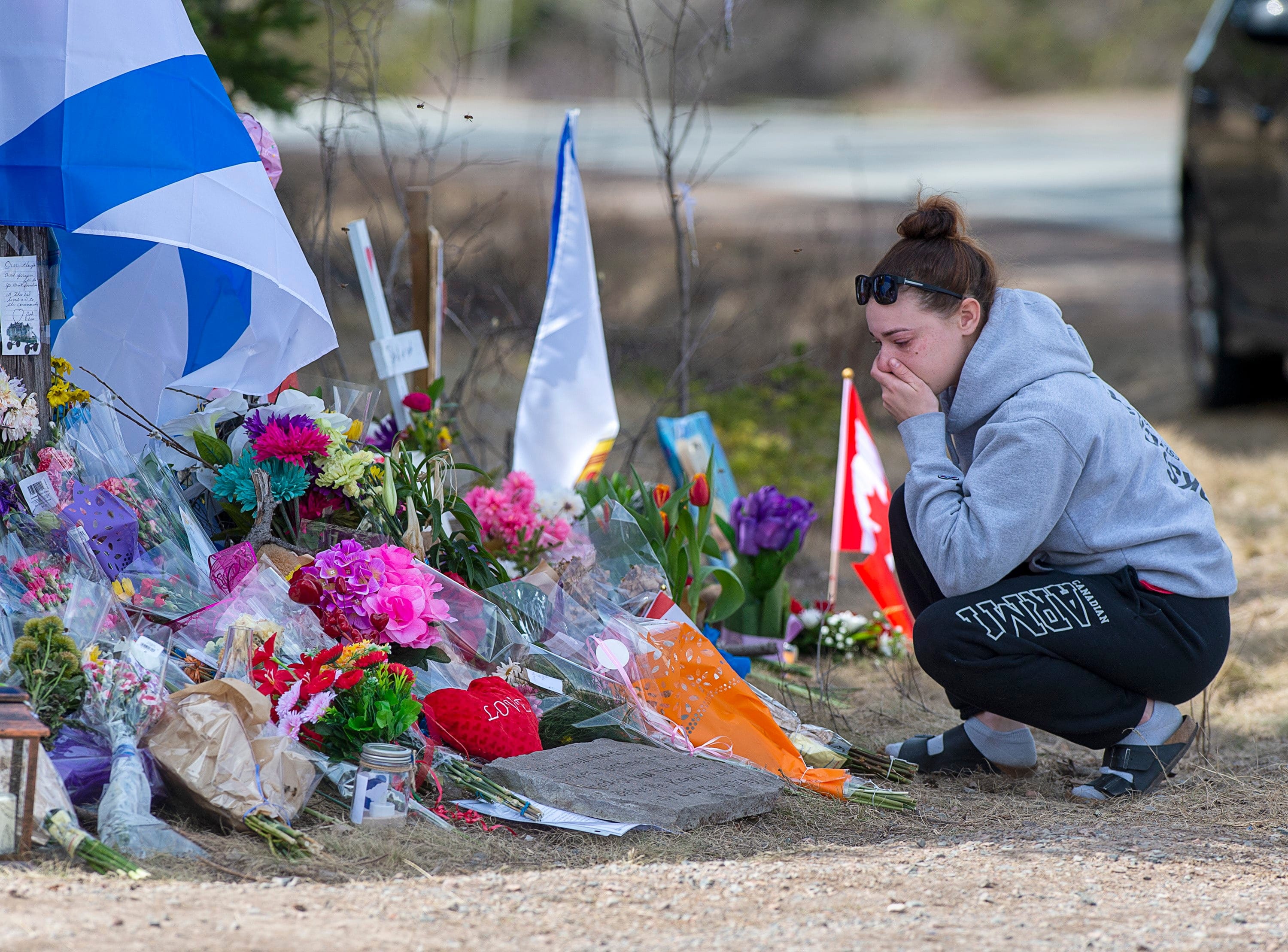A woman pays her respects at a roadside memorial on Portapique Road in Portapique, N.S. on April 24, 2020 (CP/Andrew Vaughan)