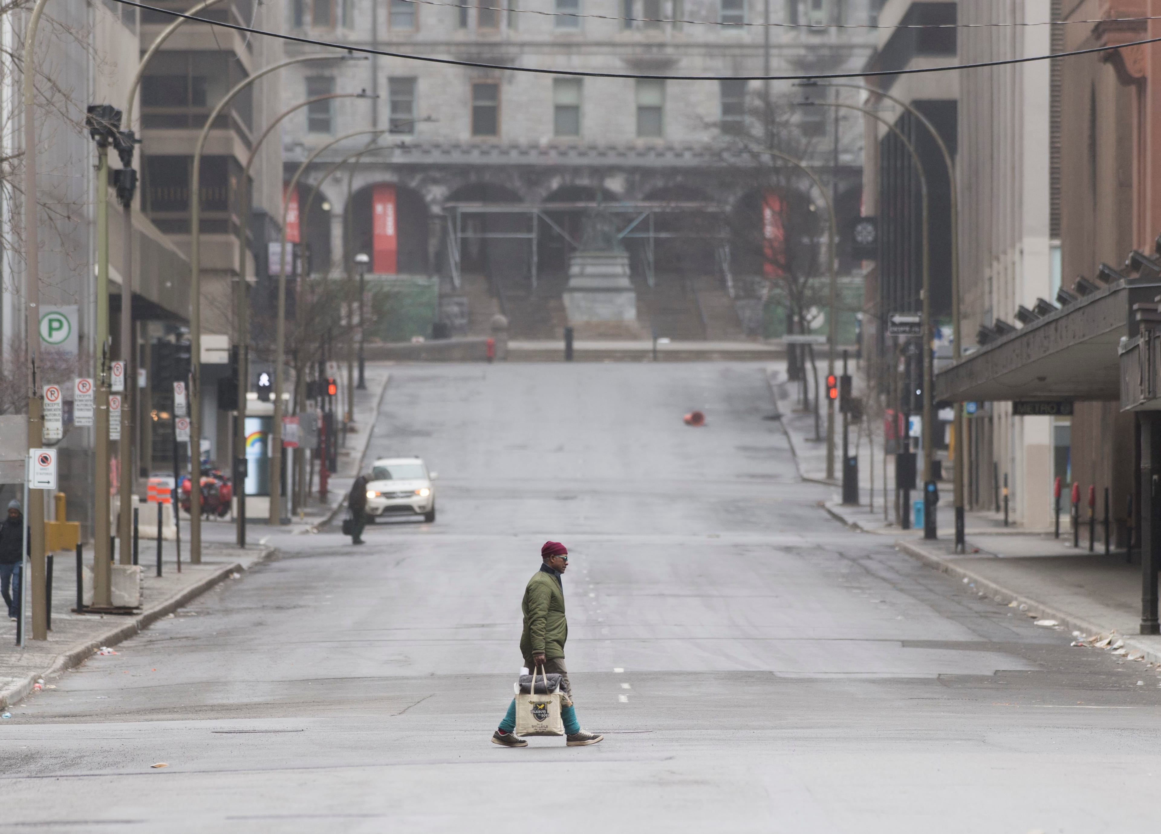People cross an empty street in downtown Montreal, Sunday, April 5, 2020, as Coronavirus COVID-19 cases rise in Canada and around the world. photo (CP/Graham Hughes)