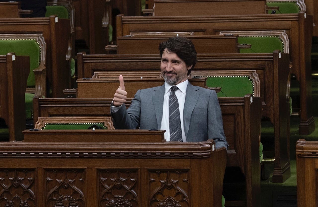 Prime Minister Justin Trudeau gives the thumbs up as he speaks with a Member of Parliament as they wait for the COVID-19 committee in the House of Commons Chamber Wednesday April 29, 2020 in Ottawa. (Adrian Wyld/CP)