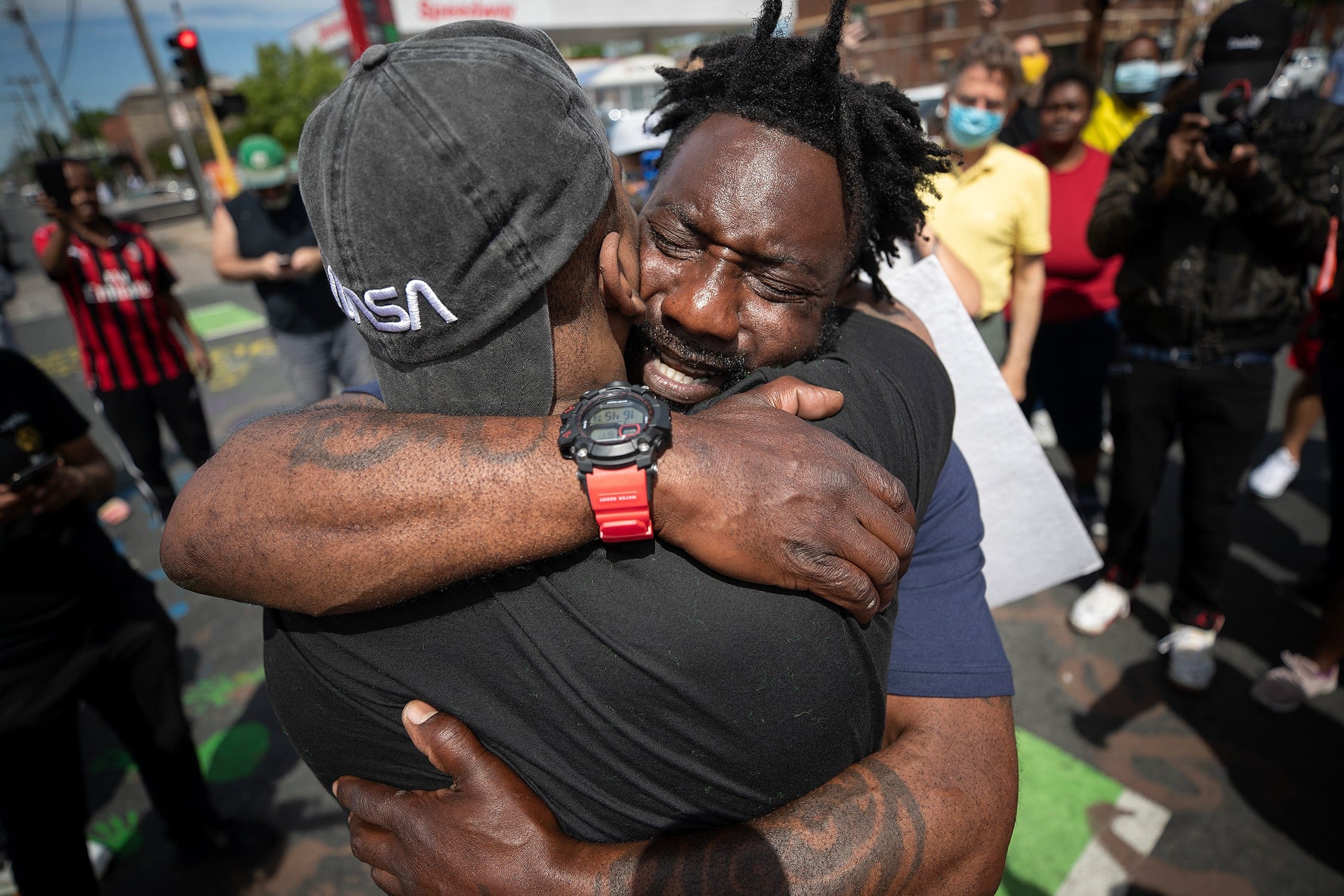 Former NFL player Tyrone Carter hugs a protester at the site where George Floyd was killed (Jerry Holt/Star Tribune/ Getty Images)