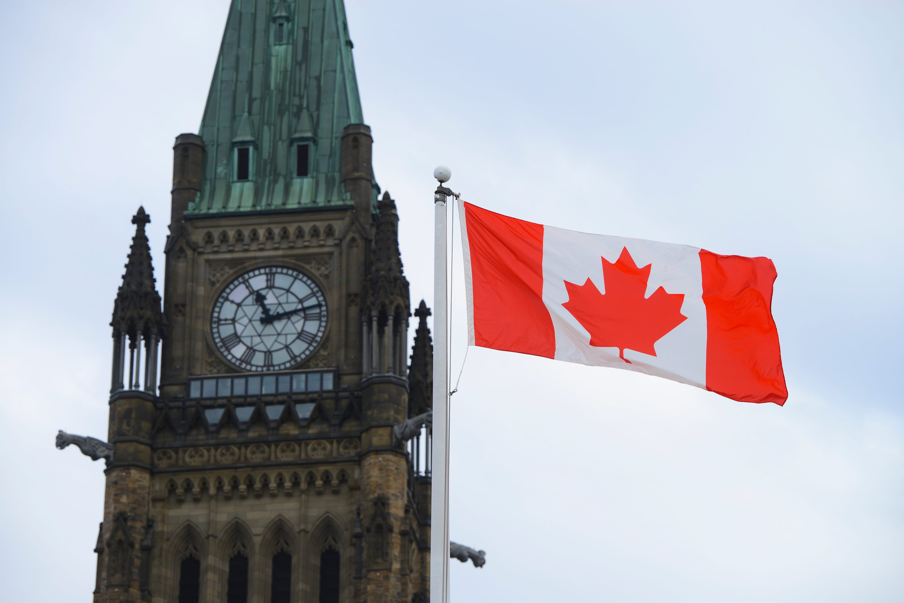 A Canadian flag flies by Parliament Hill in Ottawa on Friday, March 13, 2020. (Sean Kilpatrick/CP)