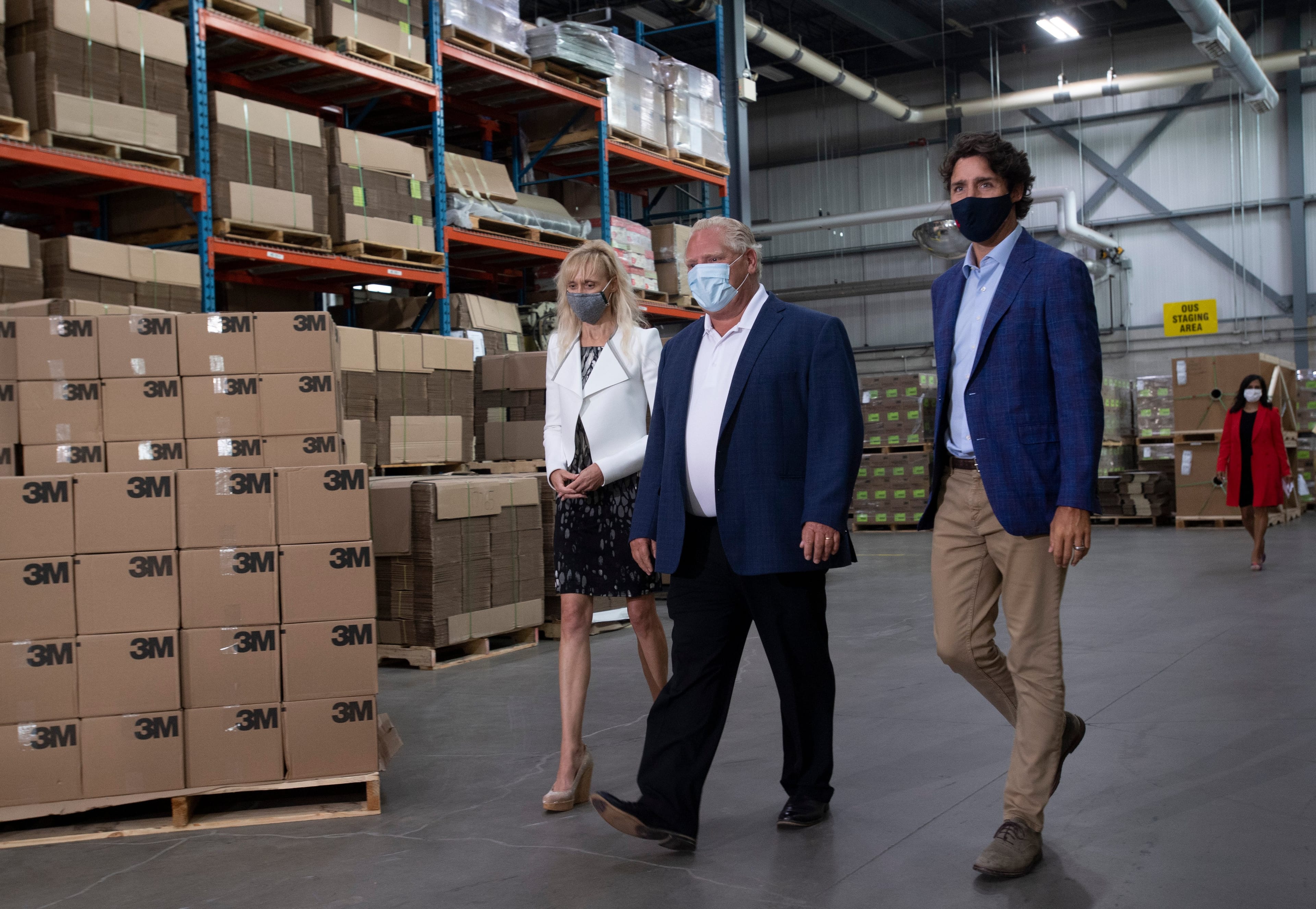 3M Canada President Penny Wise, Ontario Premier Doug Ford and Prime Minister Justin Trudeau make their way to an announcement at a facility in Brockville, Ont., Friday, Aug. 21, 2020. (Adrian Wyld/CP)