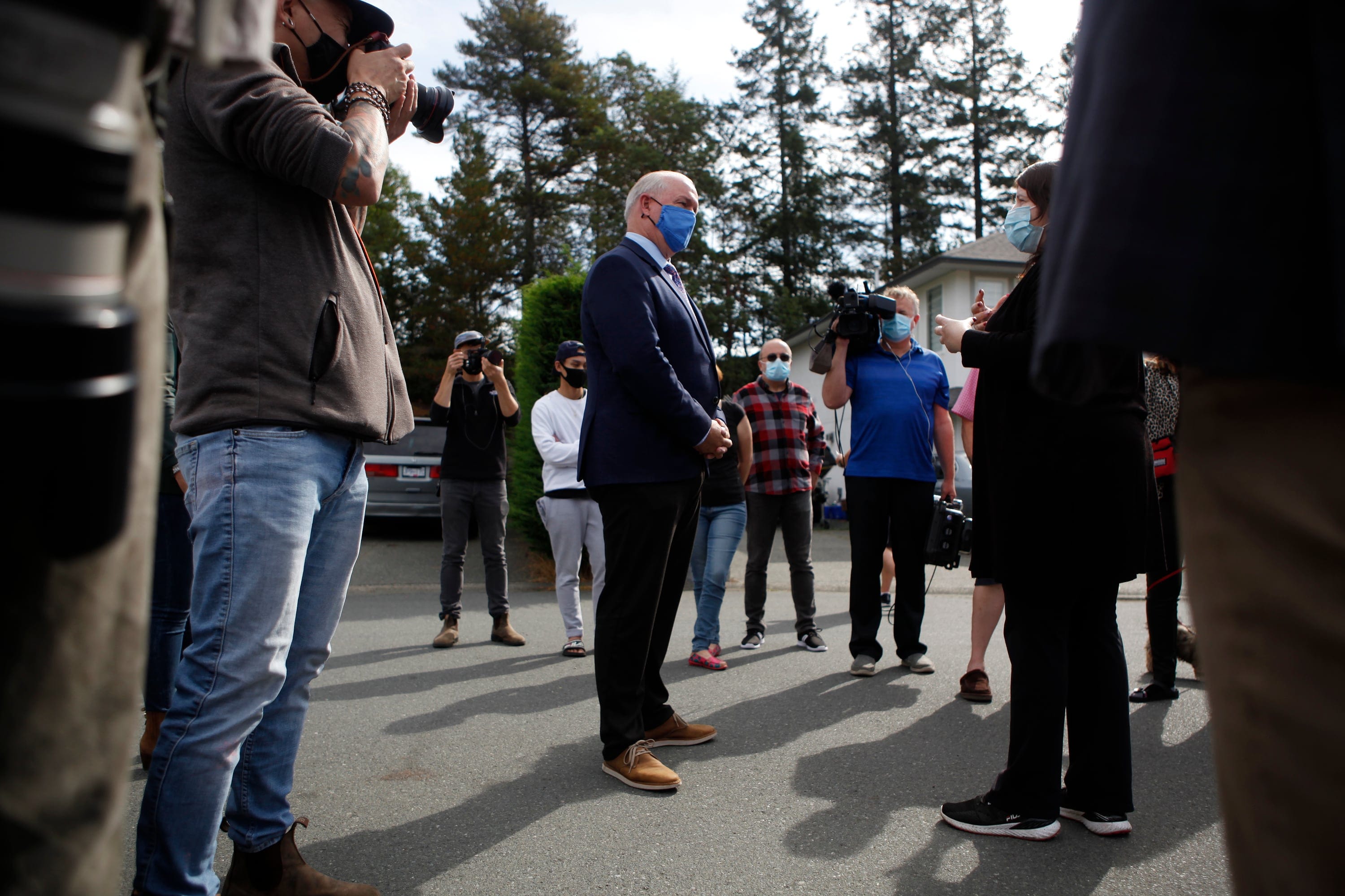 Premier John Horgan listens as concerned resident Tara Koshman asks him a question about the fall election he just announced following a press conference in Langford, B.C., on Monday September 21, 2020. (Chad Hipolito/CP)