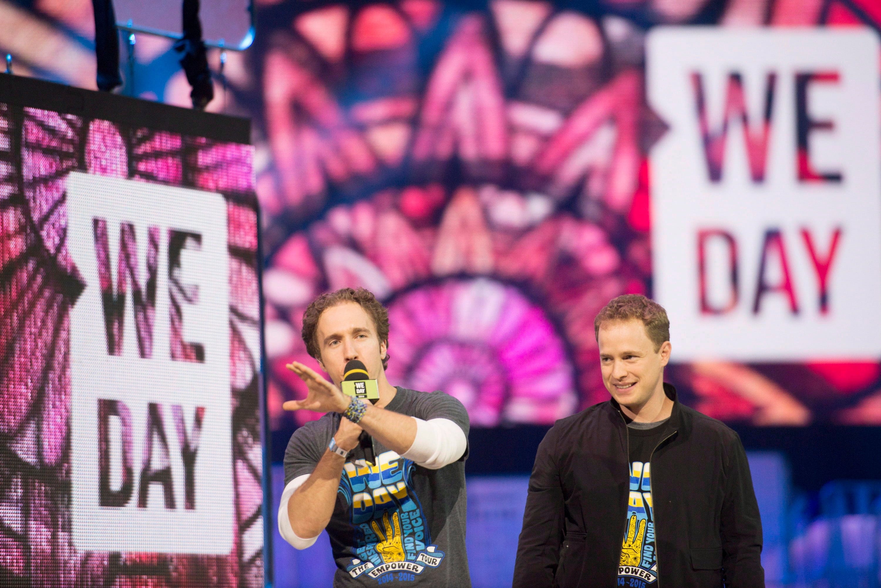 Craig Kielburger and Marc Kielburger speak during "We Day" in Toronto on Thursday, Oct. 2, 2014. (Hannah Yoon/CP)