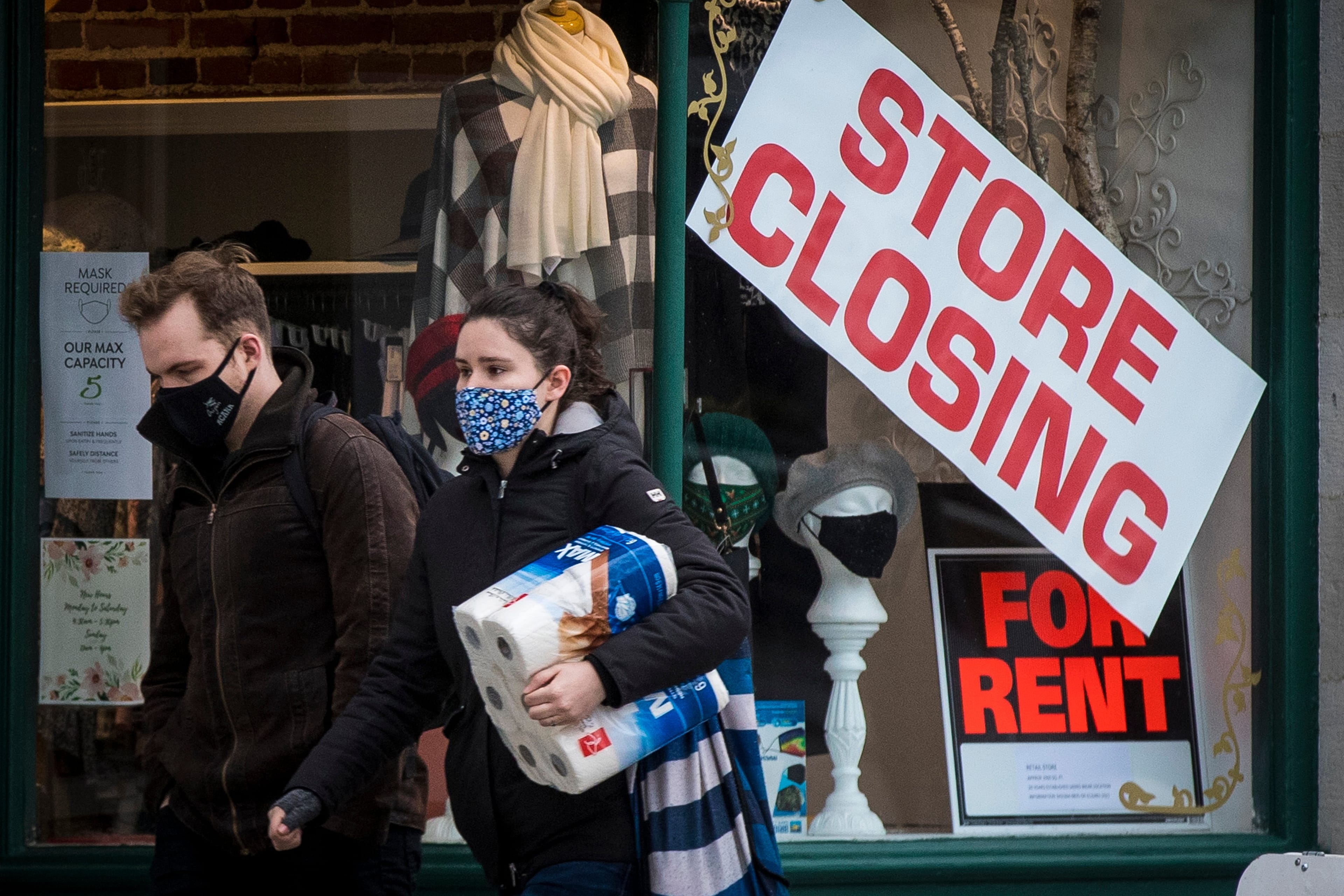 People wears masks as they walk past a store that is closing in Kingston, Ontario on Monday, November 16, 2020, as the COVID-19 pandemic continues across Canada and around the world. (Lars Hagberg/CP)