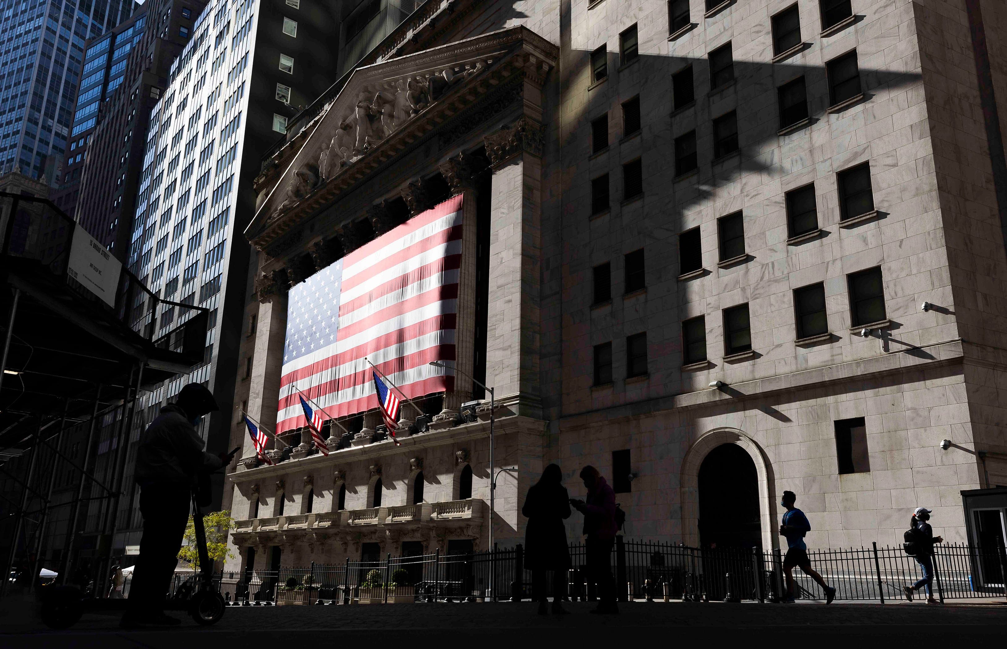 People walk past the New York Stock Exchange on Wall Street in New York on Nov. 4, 2020 (Justin Lane/EPA/CP)
