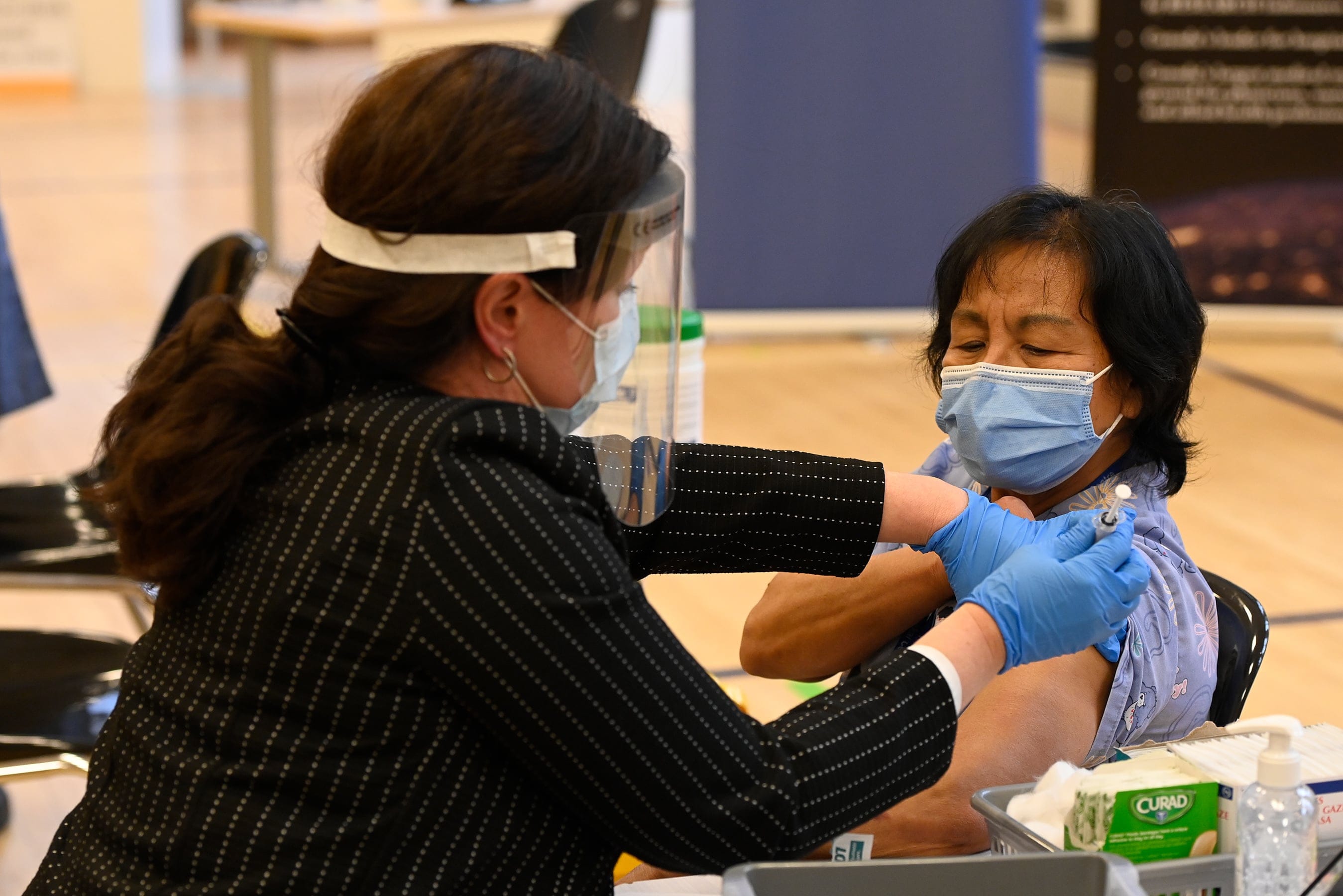 Tamara Dus (left), director of University Health Netwok Safety Services, administers the first Pfizer-BioNTech COVID-19 vaccine in Ontario to personal support worker Anita Quidangen at a hospital in Toronto on Monday, Dec. 14, 2020. (Frank Gunn/CP)