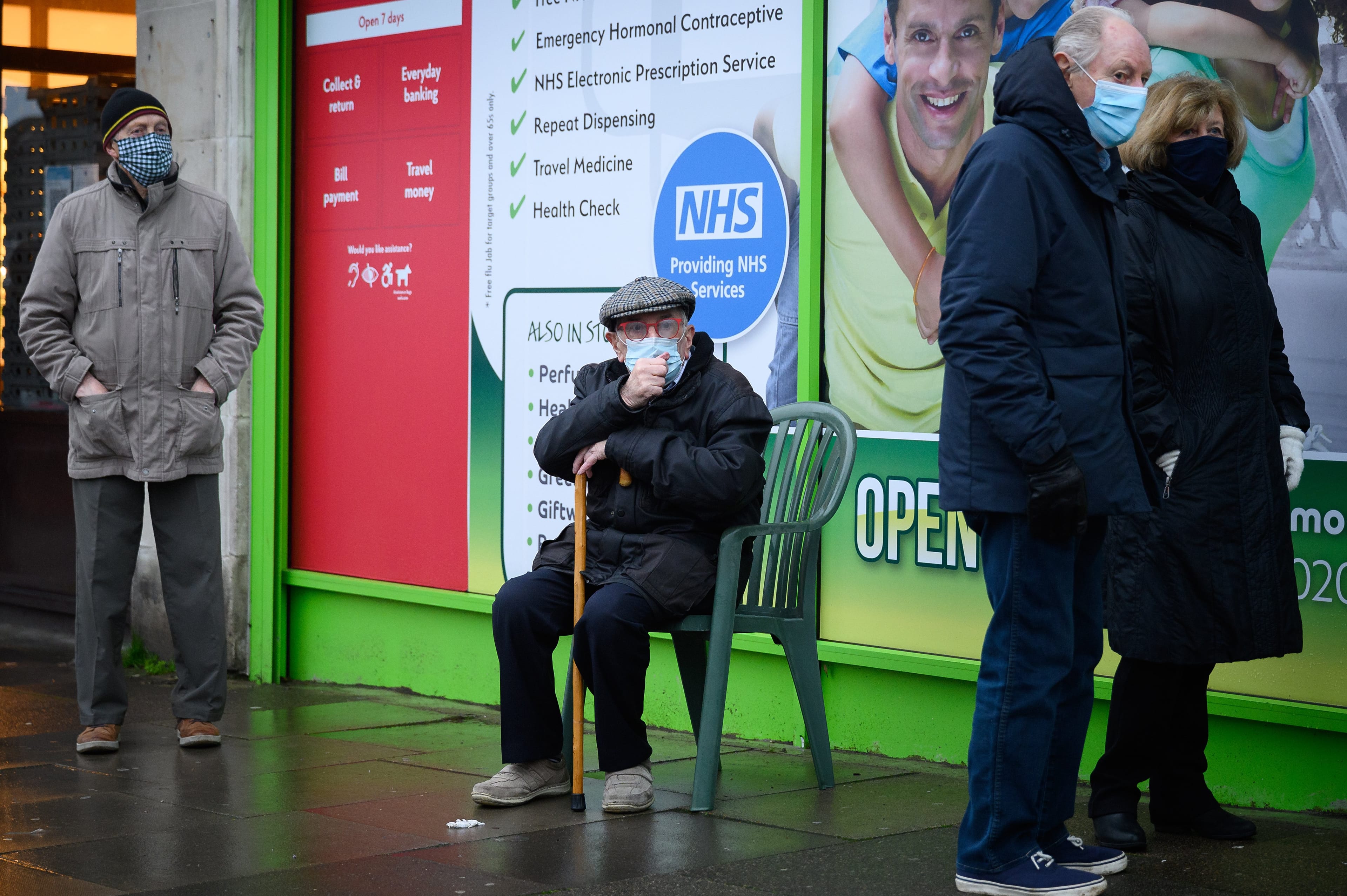 LONDON, ENGLAND - JANUARY 14: People queue for their appointments outside the Cullimore independent community chemist in Edgware after it became the first pharmacy in London to offer access to the COVID-19 vaccination on January 14, 2021 in London, England. Six pharmacies around England began administering vaccines by appointment to qualified recipients, with 200 more scheduled to start over the next two weeks. (Photo by Leon Neal/Getty Images)