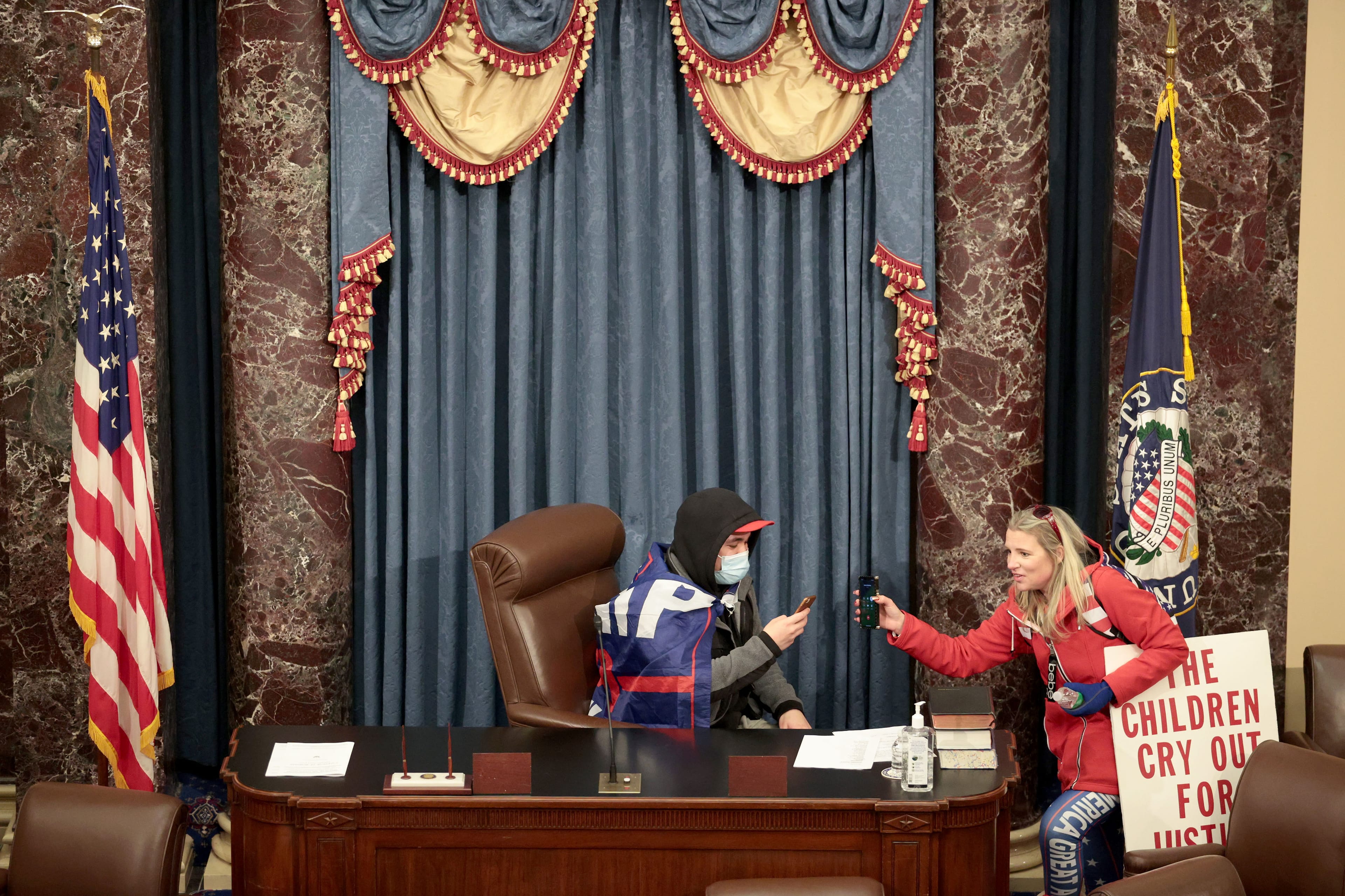 A rioter takes a seat in the Senate Chamber on Wednesday. (Win McNamee/Getty Images)