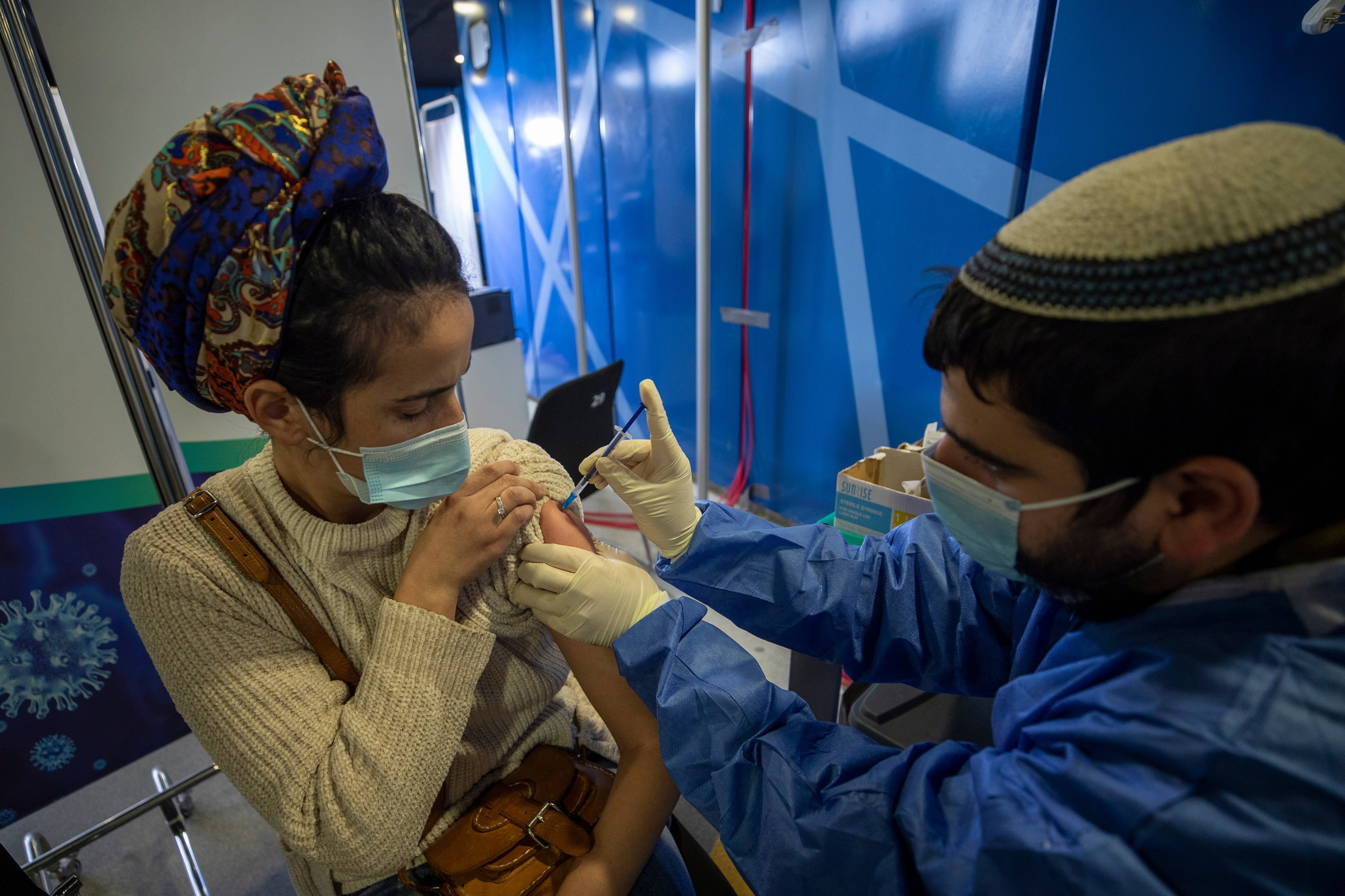 A woman is vaccinated against COVID-19 on Tuesday in the Medical Center in Jerusalem. Israel had by this point vaccinated over four and a-half million of its nine million citizens; three million had been given a second dose. (Atef Safadi/EPA via CP)