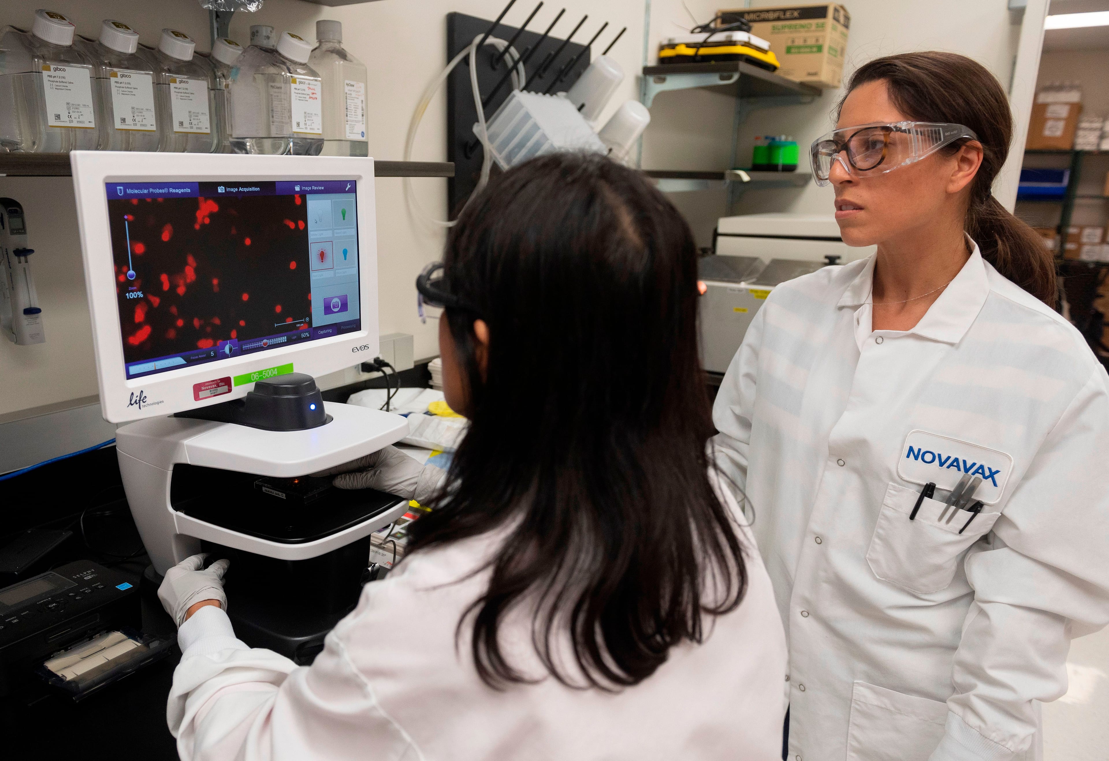 Dr. Sonia Macieiewski (R) and Dr. Nita Patel, Director of Antibody discovery and Vaccine development, look at a sample of a respiratory virus at Novavax labs in Gaithersburg, Maryland on March 20, 2020, for the coronavirus, COVID-19. (Photo by ANDREW CABALLERO-REYNOLDS/AFP via Getty Images)