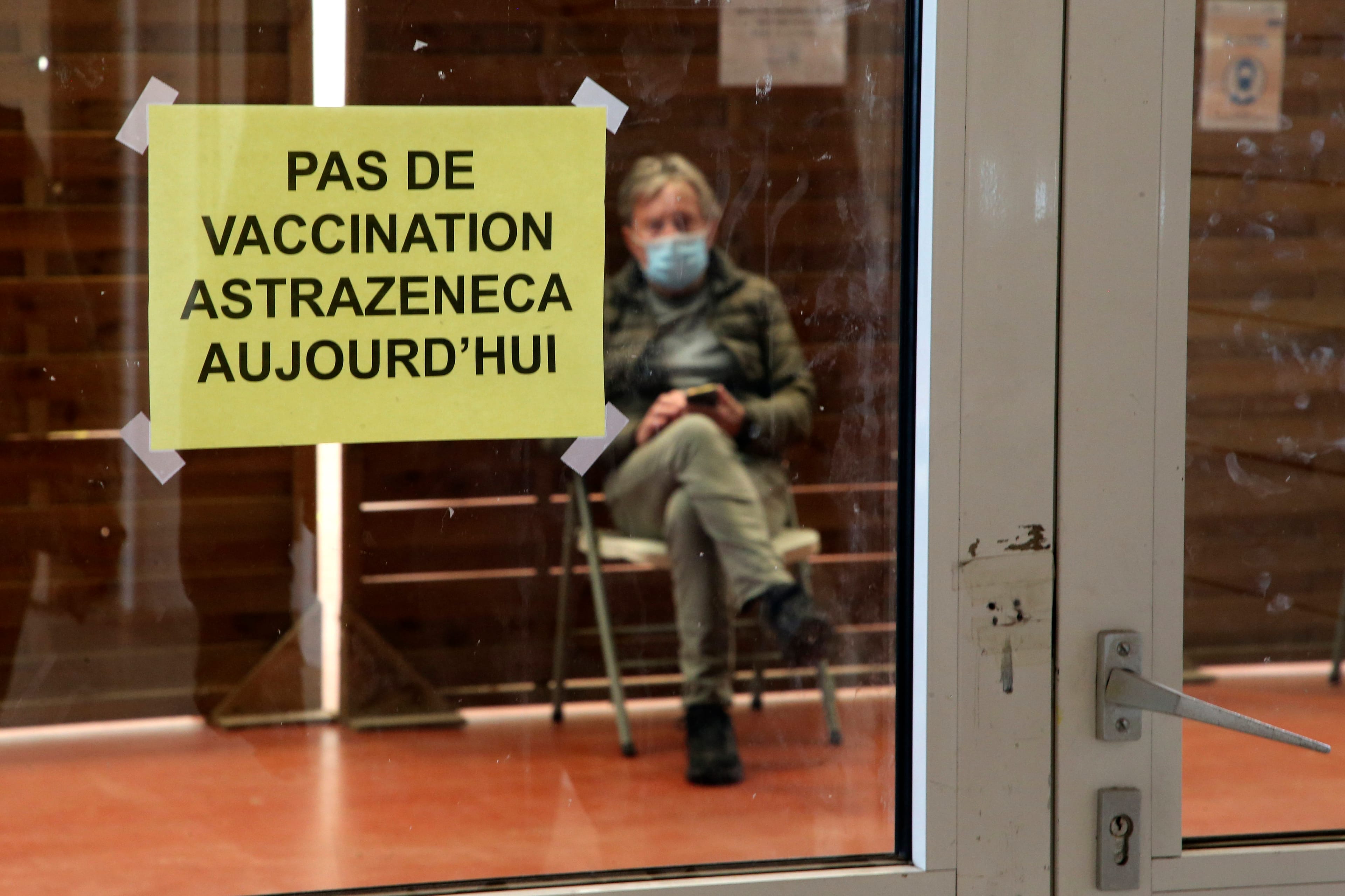 A man waits in a vaccination centre where a sign reads "No AstraZeneca vaccinations today" in Saint-Jean-de-Luz, southwestern France, Tuesday, March 16, 2021. (AP Photo/Bob Edme)