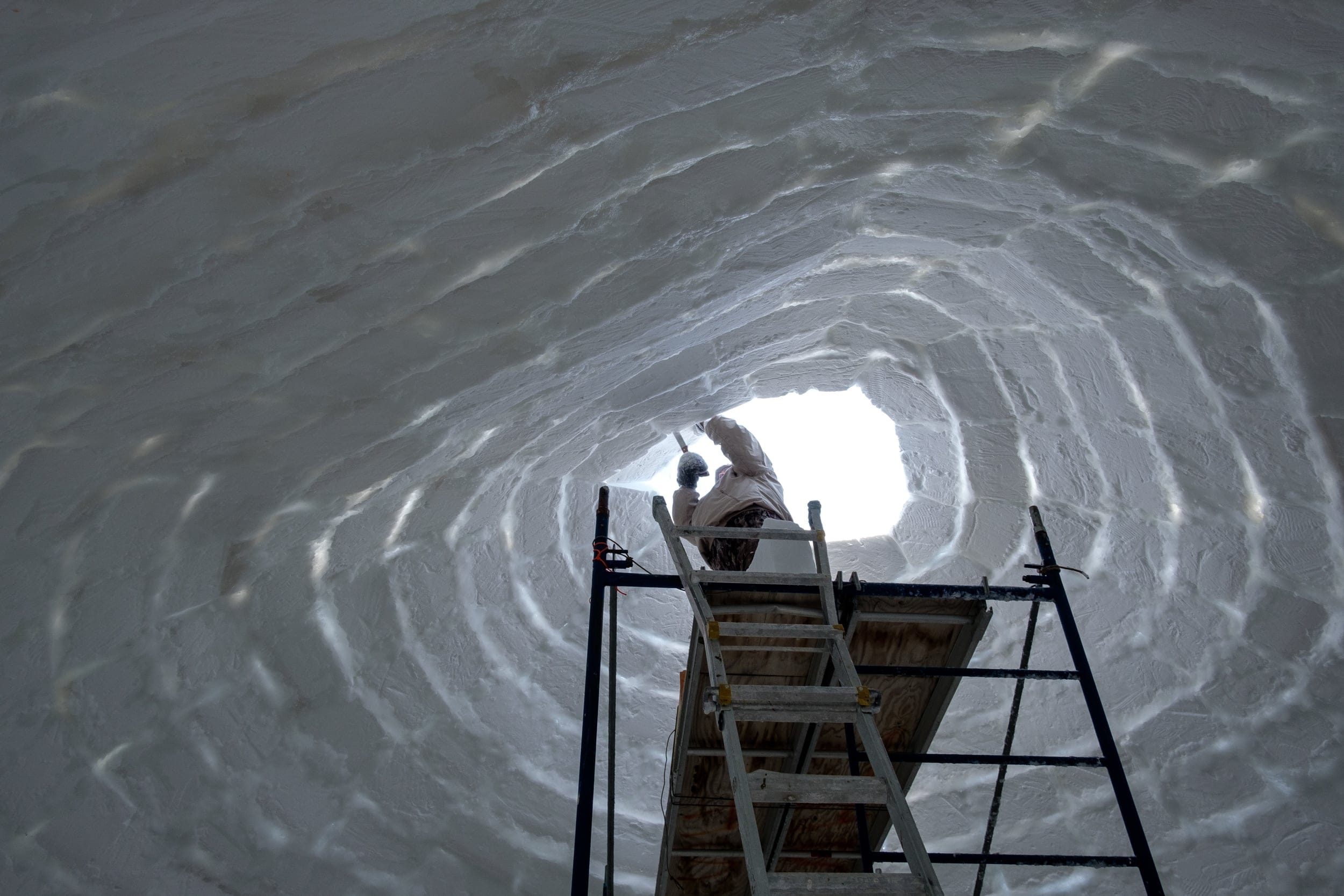 The last few blocks in the dome of the qaggiq are carefully placed (Casey Lessard)