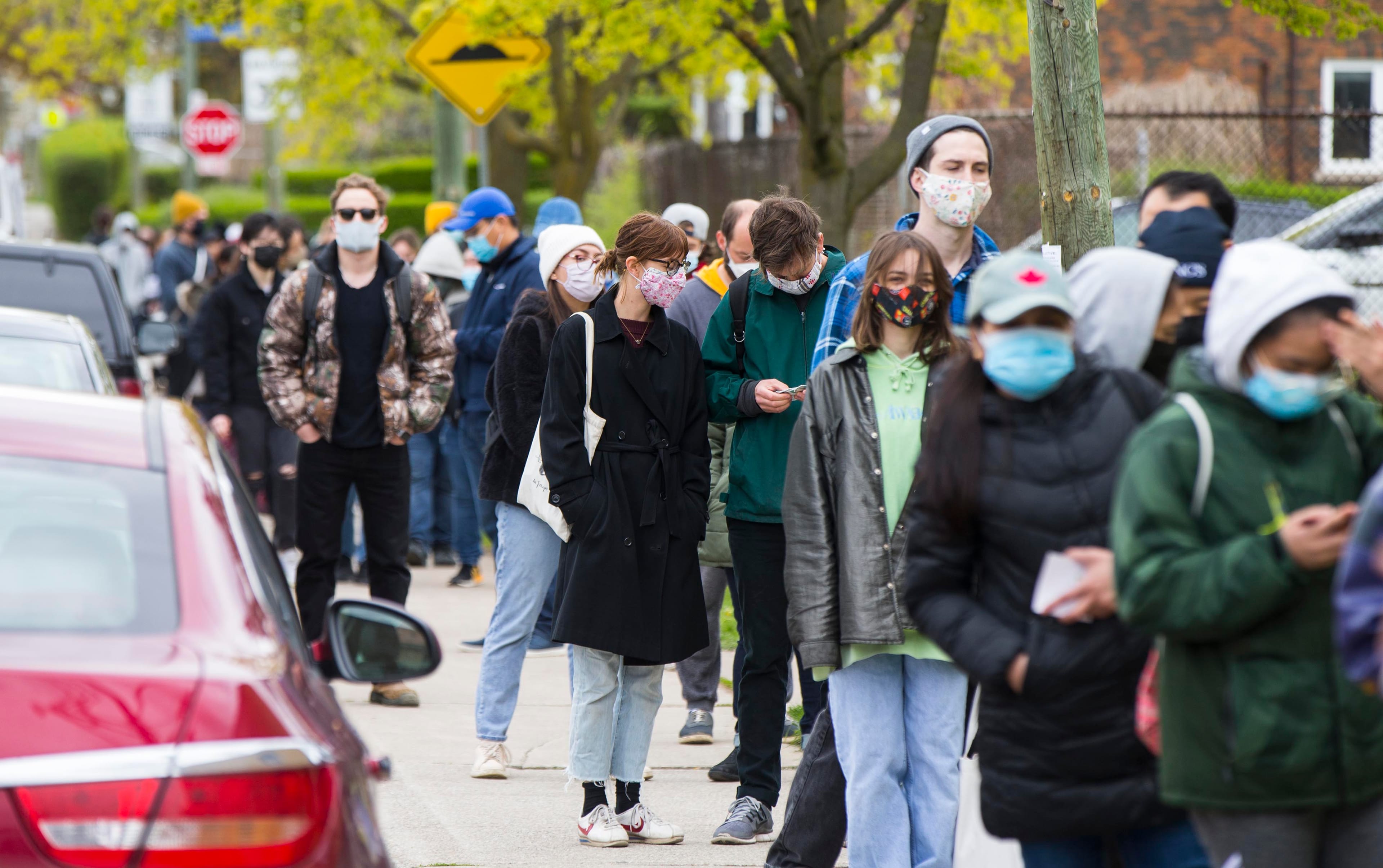 People wearing face masks line up to enter a COVID-19 vaccination clinic in Toronto on May 5, 2021. (Zou Zheng/Xinhua via ZUMA Press)