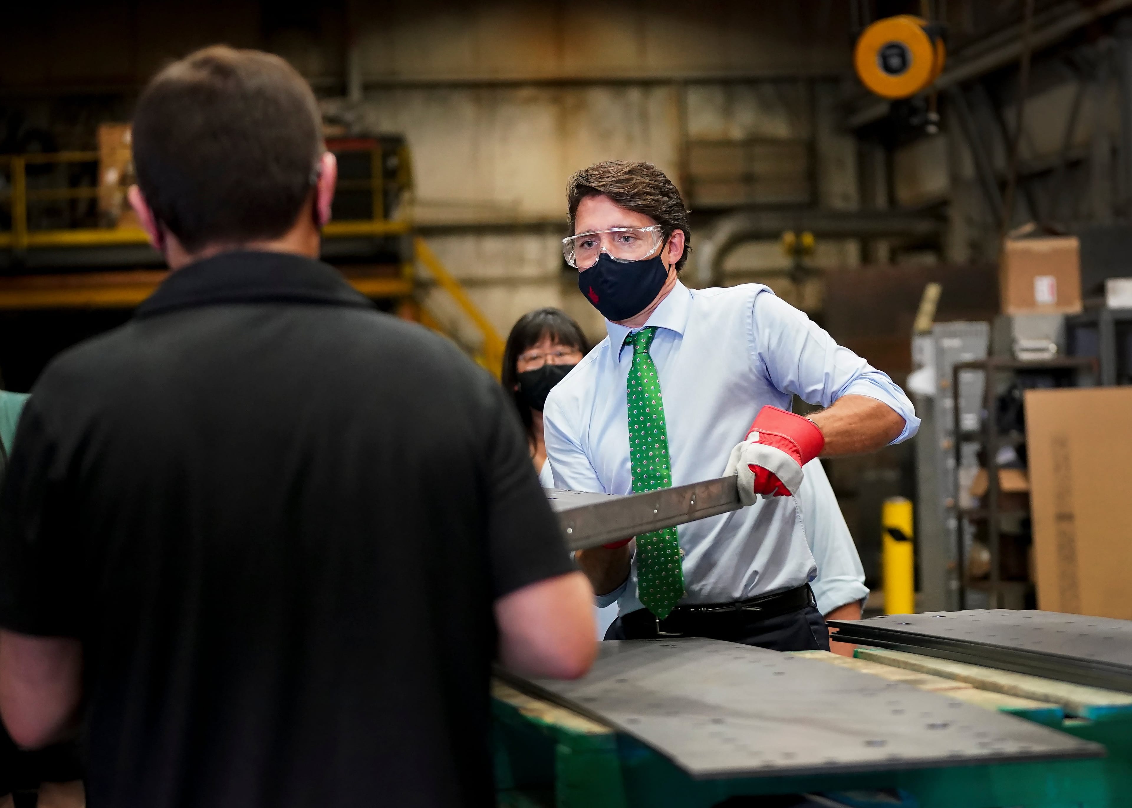Trudeau handles a piece of steel at a campaign stop in Cambridge, Ont., on Aug. 29, 2021 (Nathan Denette/CP)