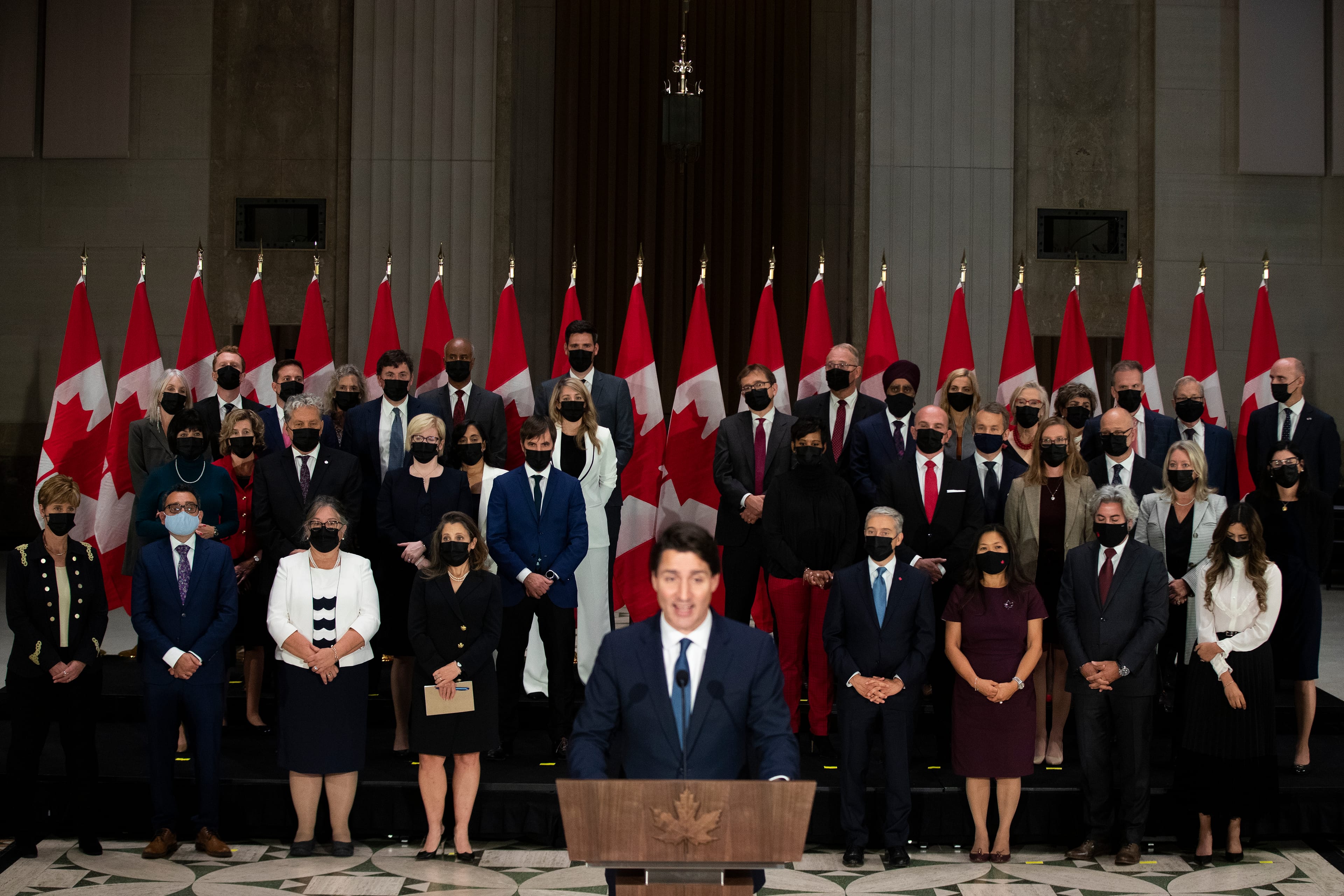 The newly sworn-in federal cabinet listens to Prime Minister Justin Trudeau during a press conference in Ottawa on Oct. 26, 2021 (Lars Hagberg/CP)