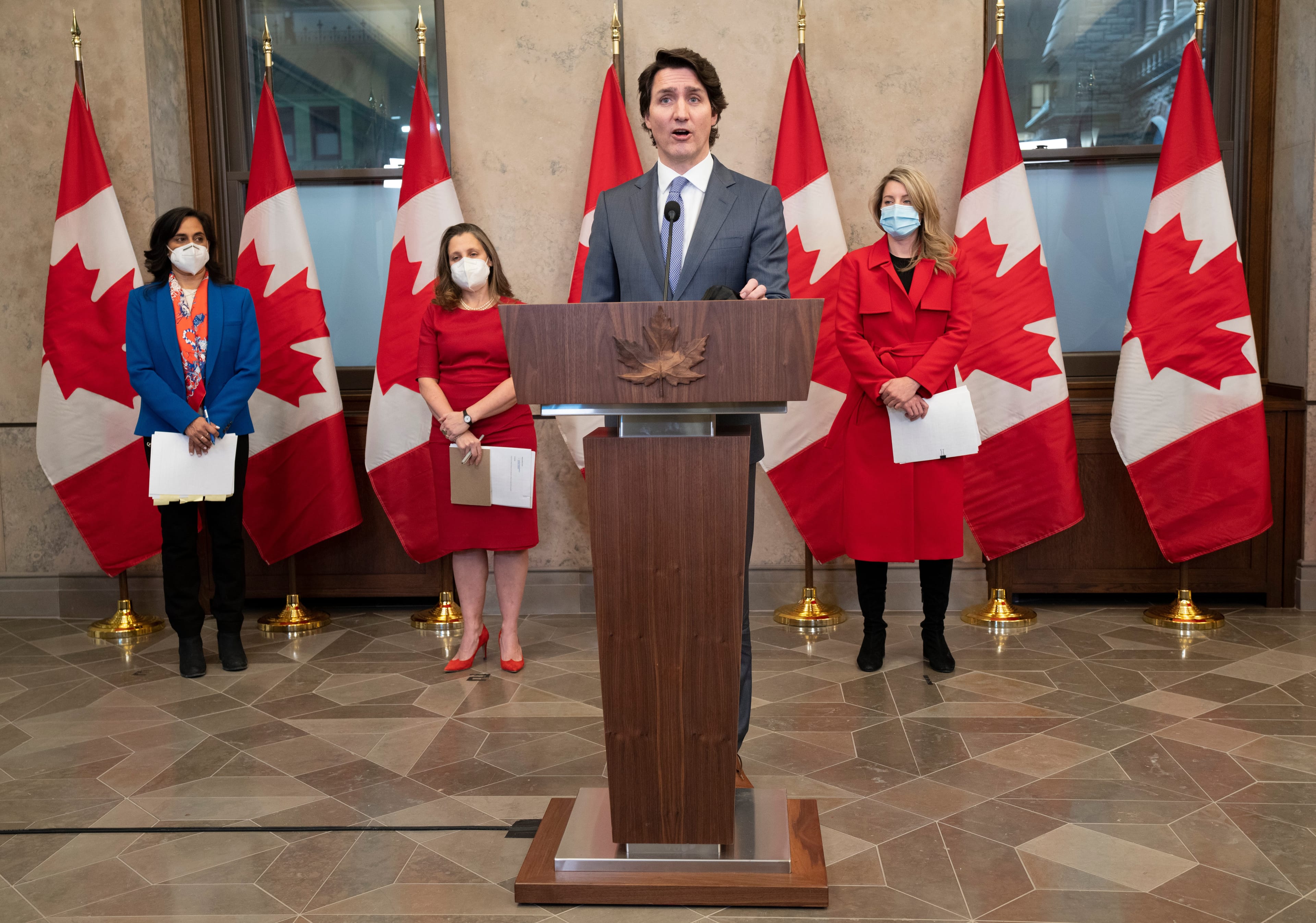 Defence Minister Anita Anand, Deputy Prime Minister and Finance Minister Chrystia Freeland and Foreign Affairs Minister Melanie Joly look on as Prime Minister Justin Trudeau speaks, Jan. 26, 2022 in Ottawa. (Adrian Wyld/The Canadian Press)