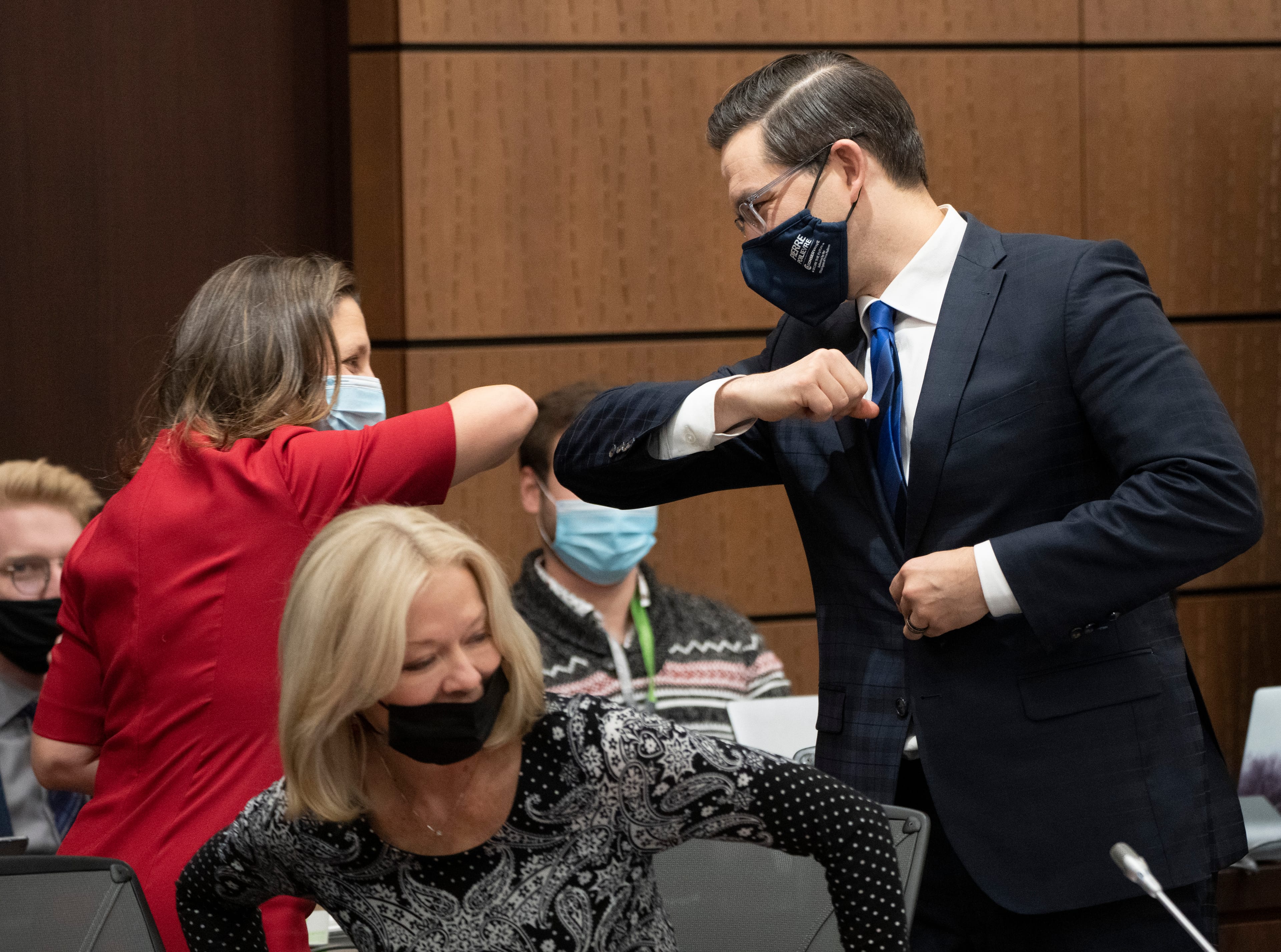Deputy Prime Minister Chrystia Freeland bumps elbows with Poilievre before appearing at the House of Commons Finance committee, on Dec. 9, 2021 in Ottawa (Adrian Wyld/CP)