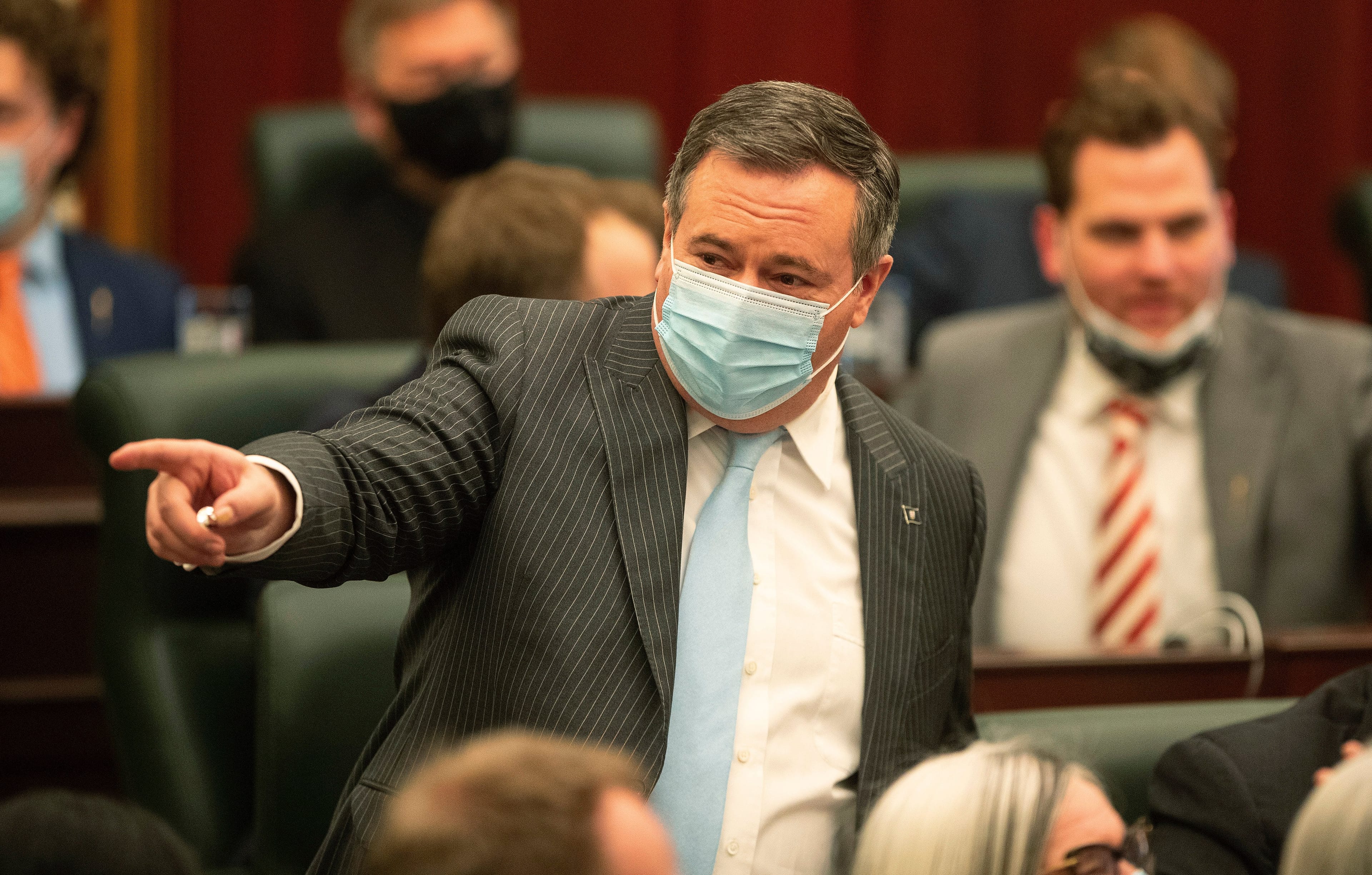 Kenney points to people in the chamber, Edmonton, Feb. 22, 2022. (Jason Franson/The Canadian Press)