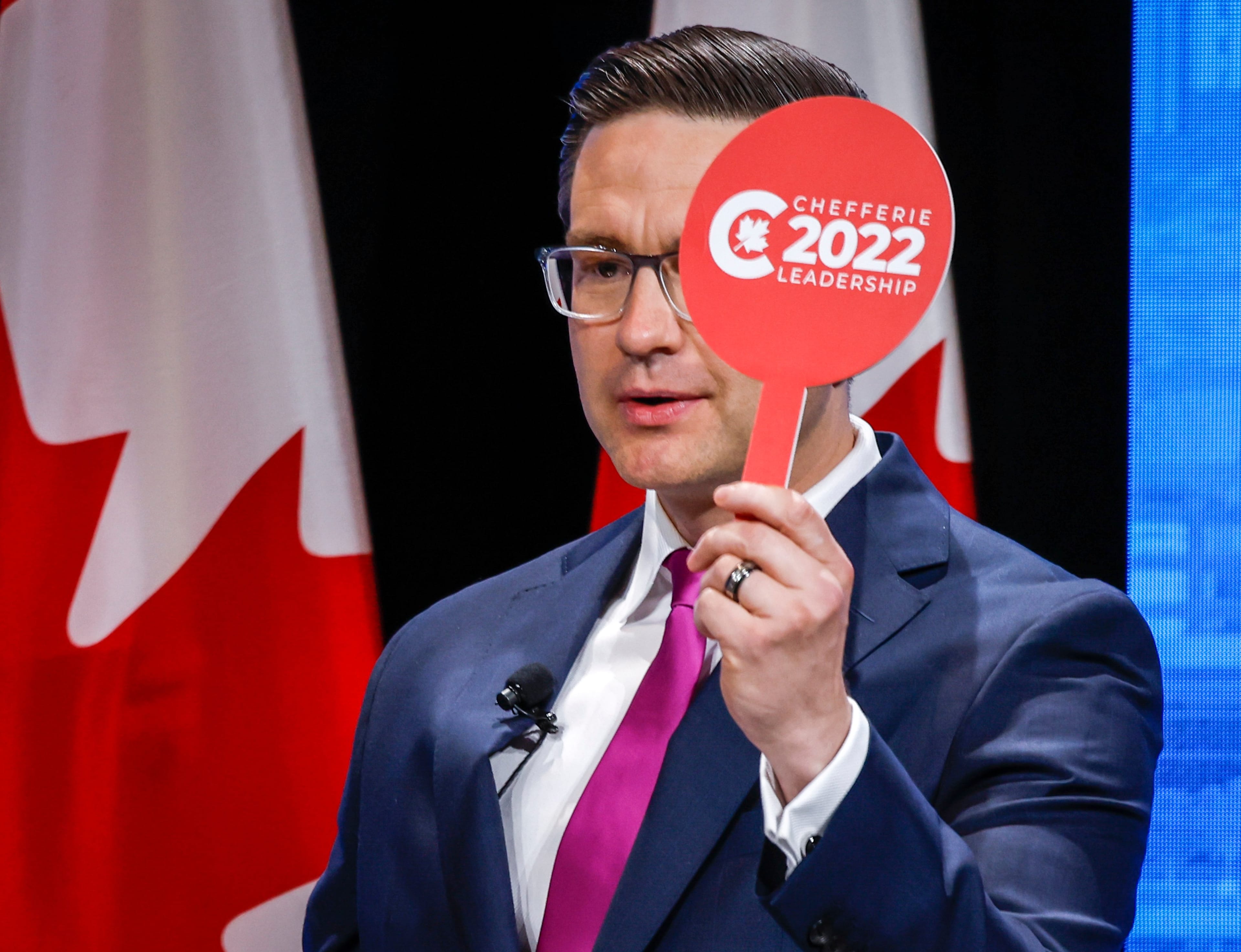 Pierre Poilievre holds his "intervention paddle" at the Conservative Party of Canada English leadership debate in Edmonton, Alta., May 11, 2022. (Jeff McIntosh/The Canadian Press)