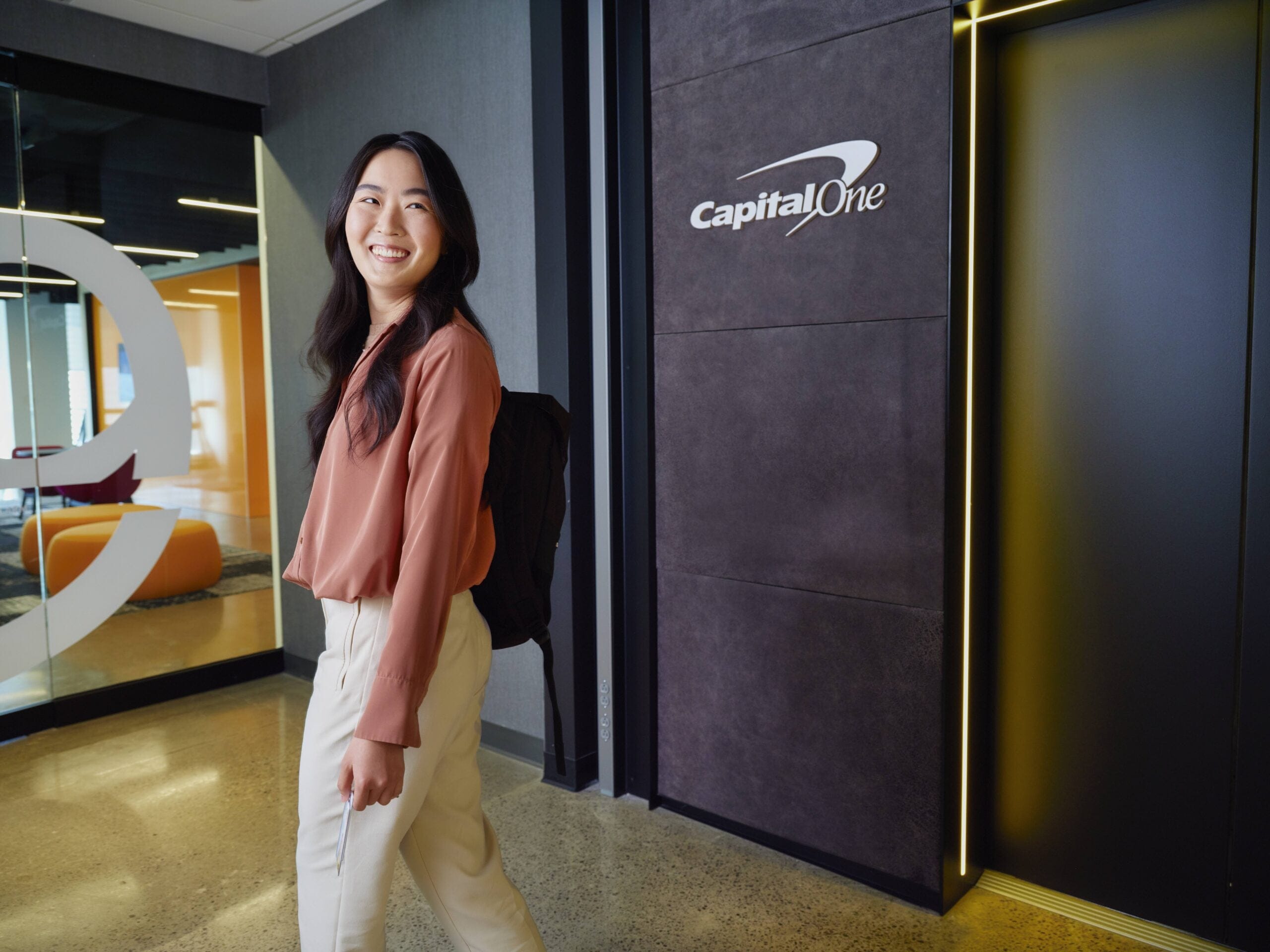 Capital One associate stands in front of office
