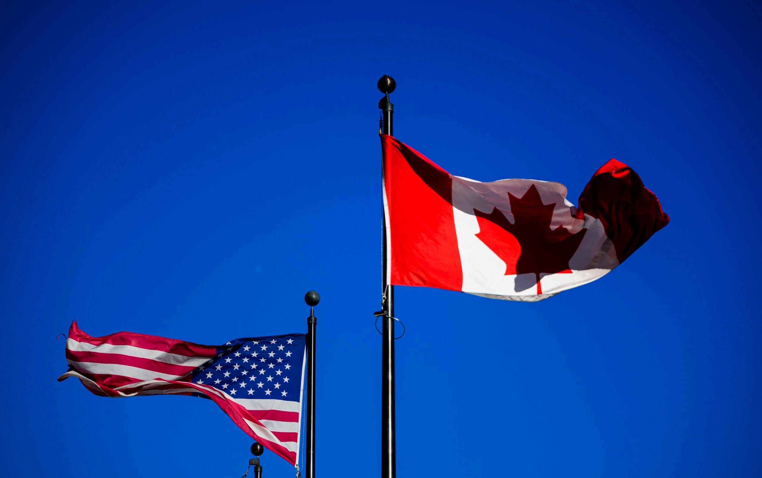 The Canadian and American flags waving in the wind