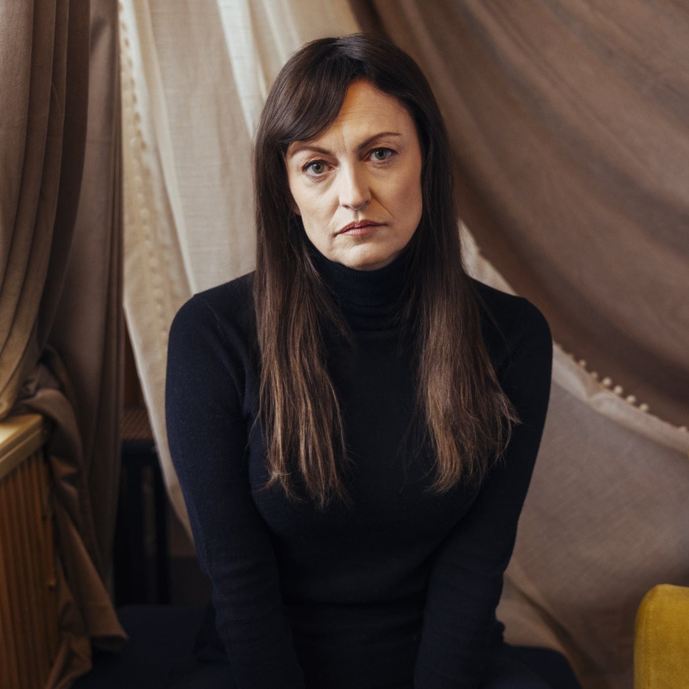 A woman with brown hair wearing a black turtleneck