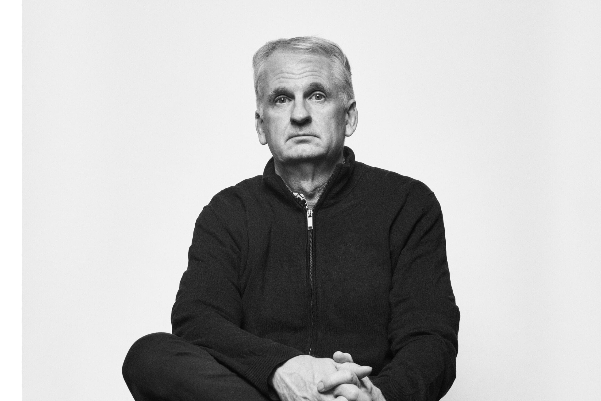 A man in a black quarter-zip sweater